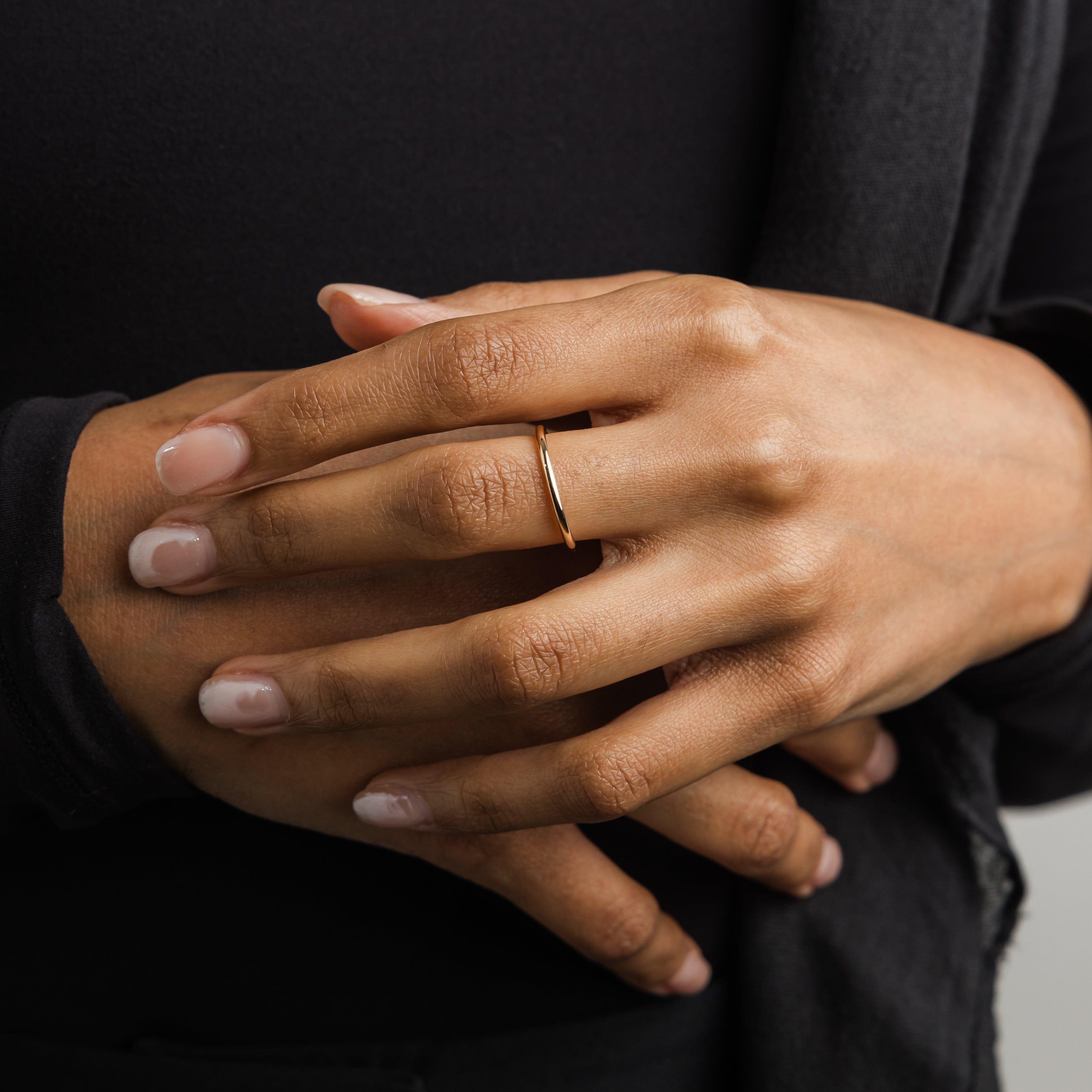 Angled view of the 14K gold thin band ring, showcasing its smooth finish.