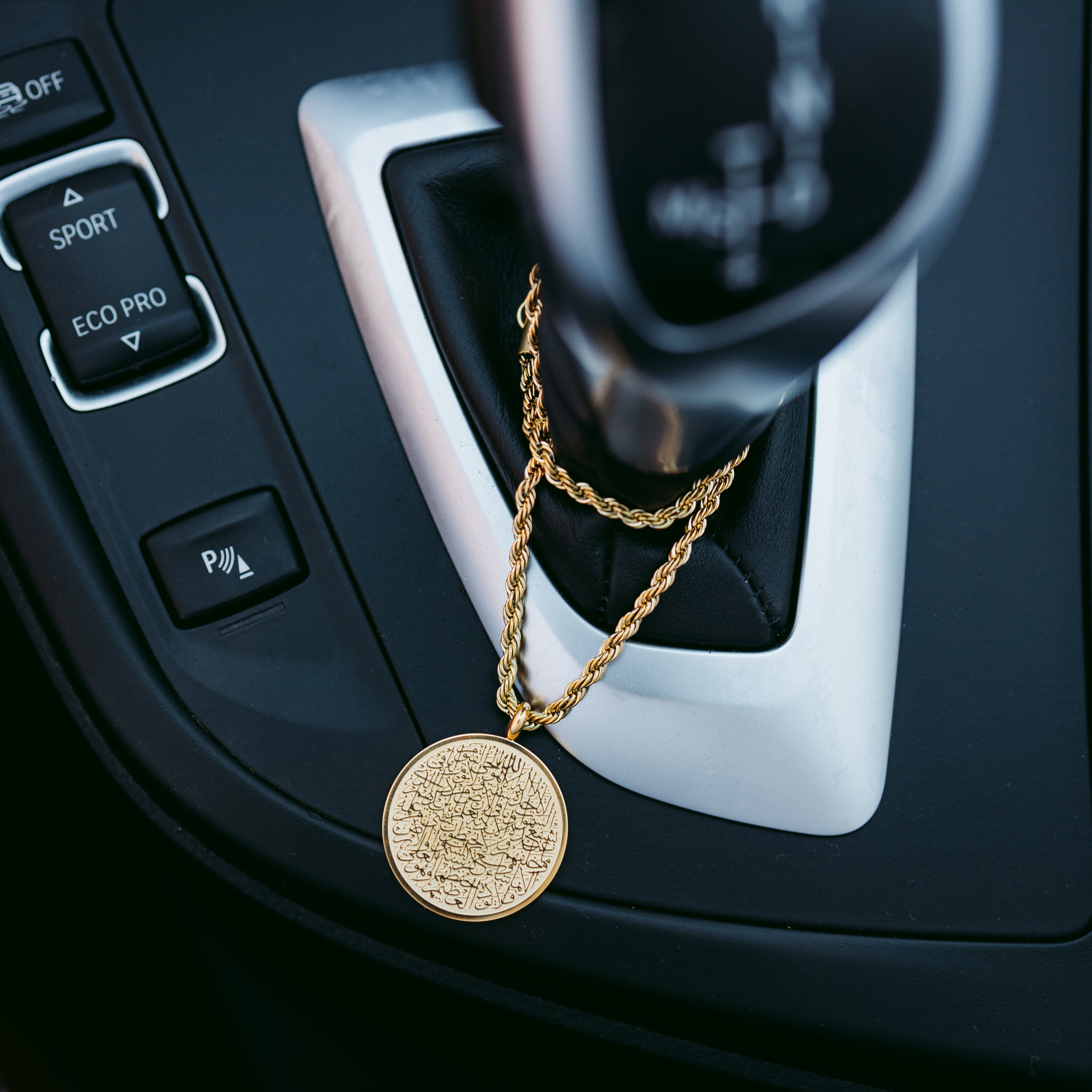 Close-up of the Ayatul Kursi Islamic pendant highlighting its gold plating.