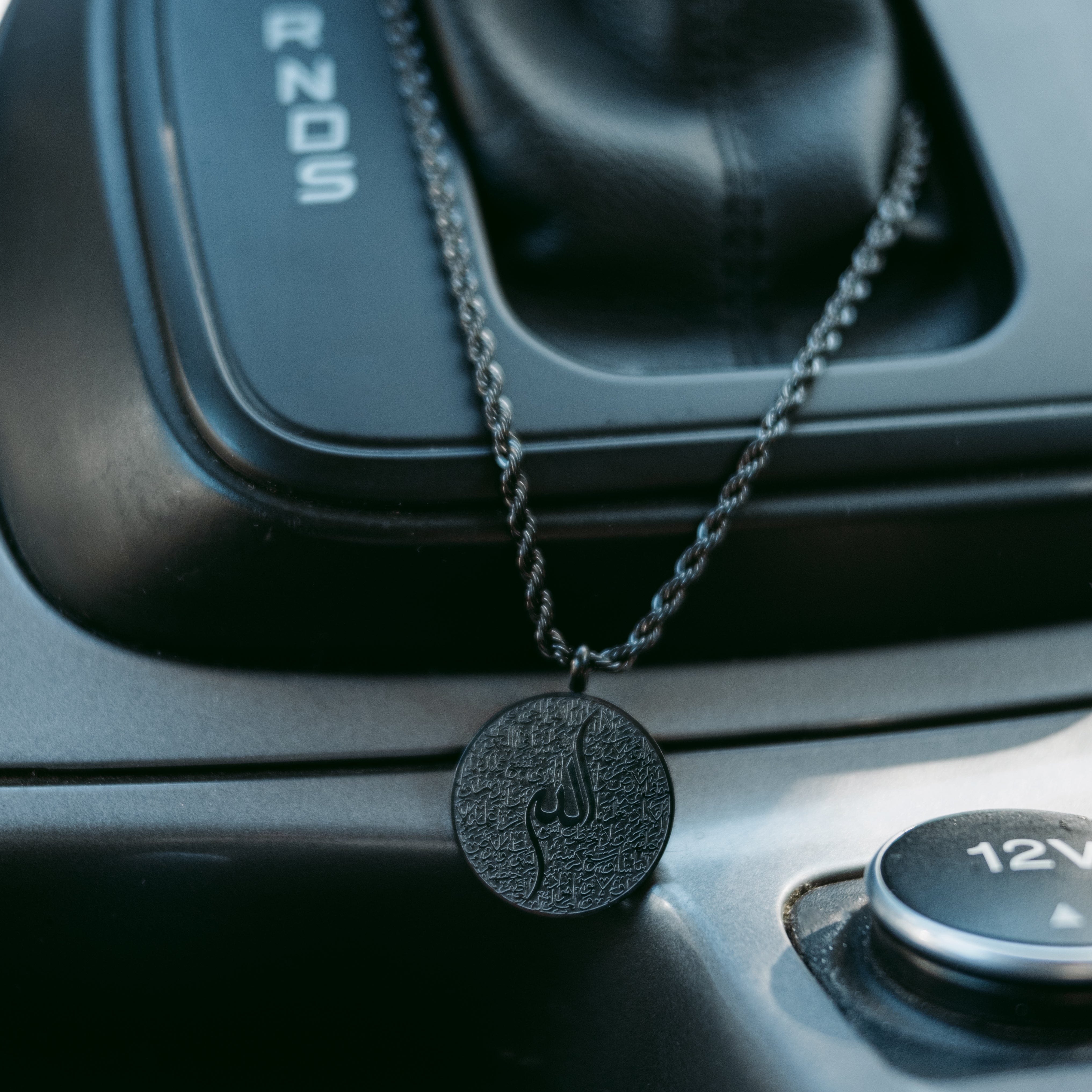 Elegant Ayatul Kursi car hanger hanging from a rearview mirror, highlighting its beauty and meaning.