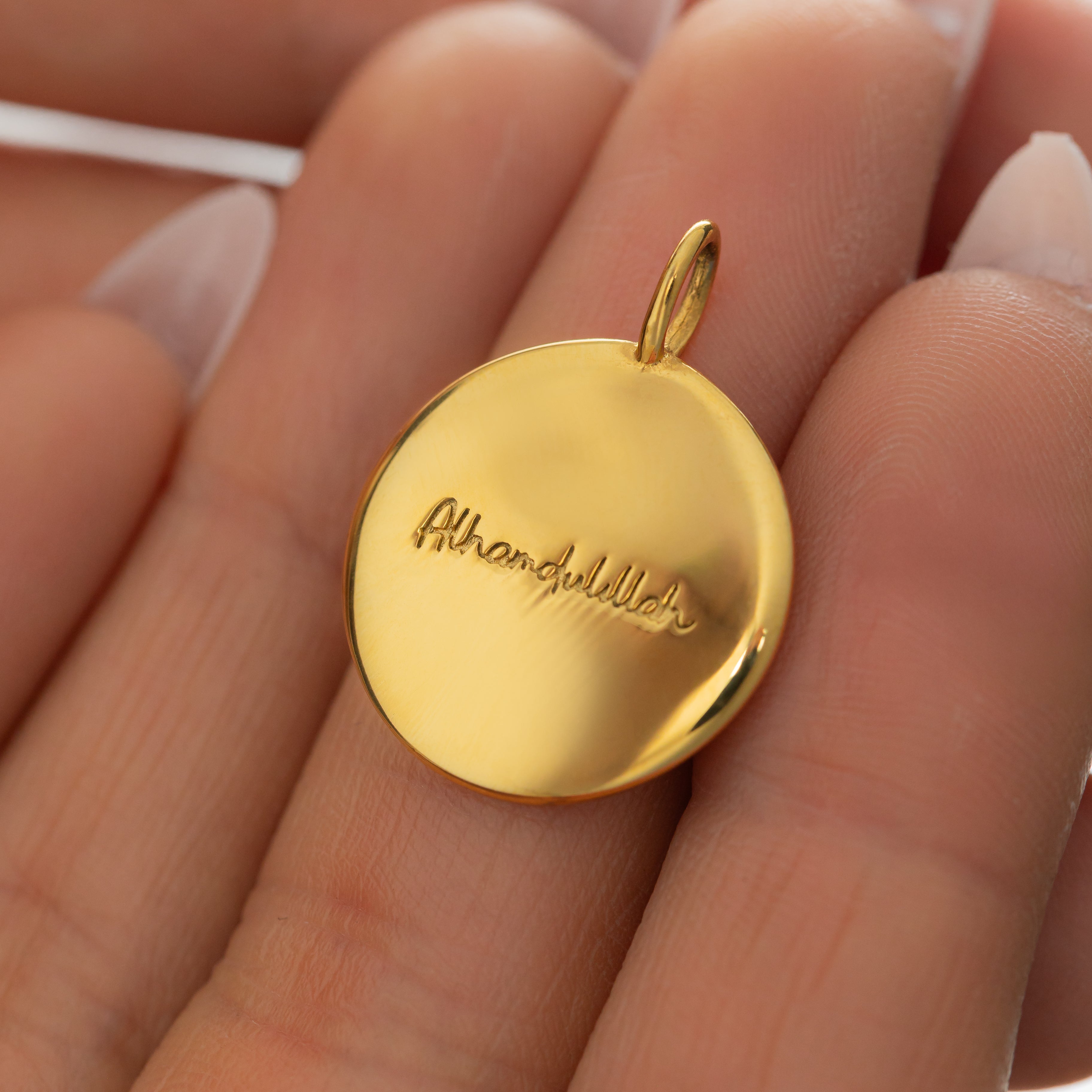 Close-up of the gold charm on a delicate chain, emphasizing its hypoallergenic properties.