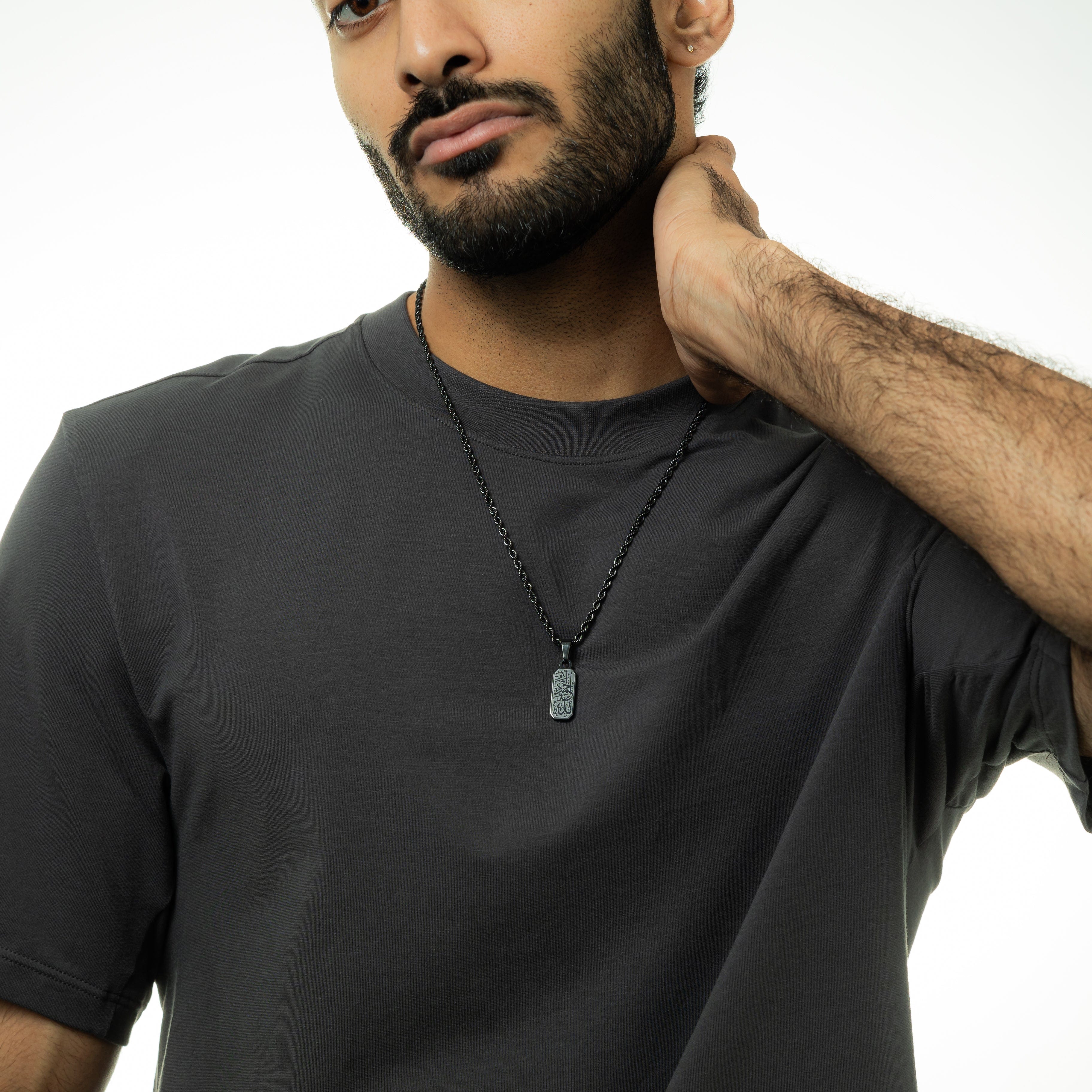 Alhamdulillah tag necklace worn by a man, emphasizing its stylish and meaningful design.