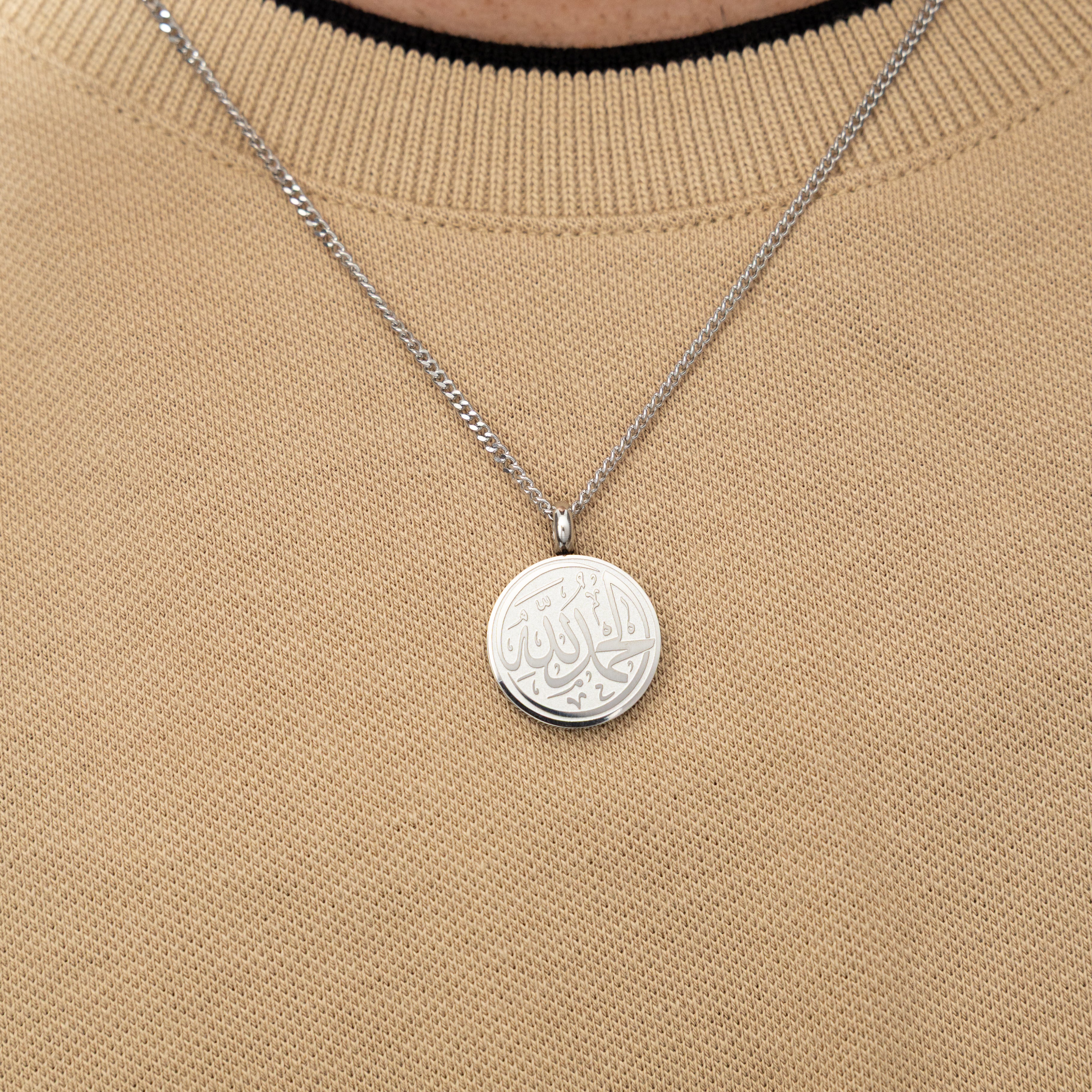 Side view of the stainless steel token necklace, highlighting its durable chain and pendant size.