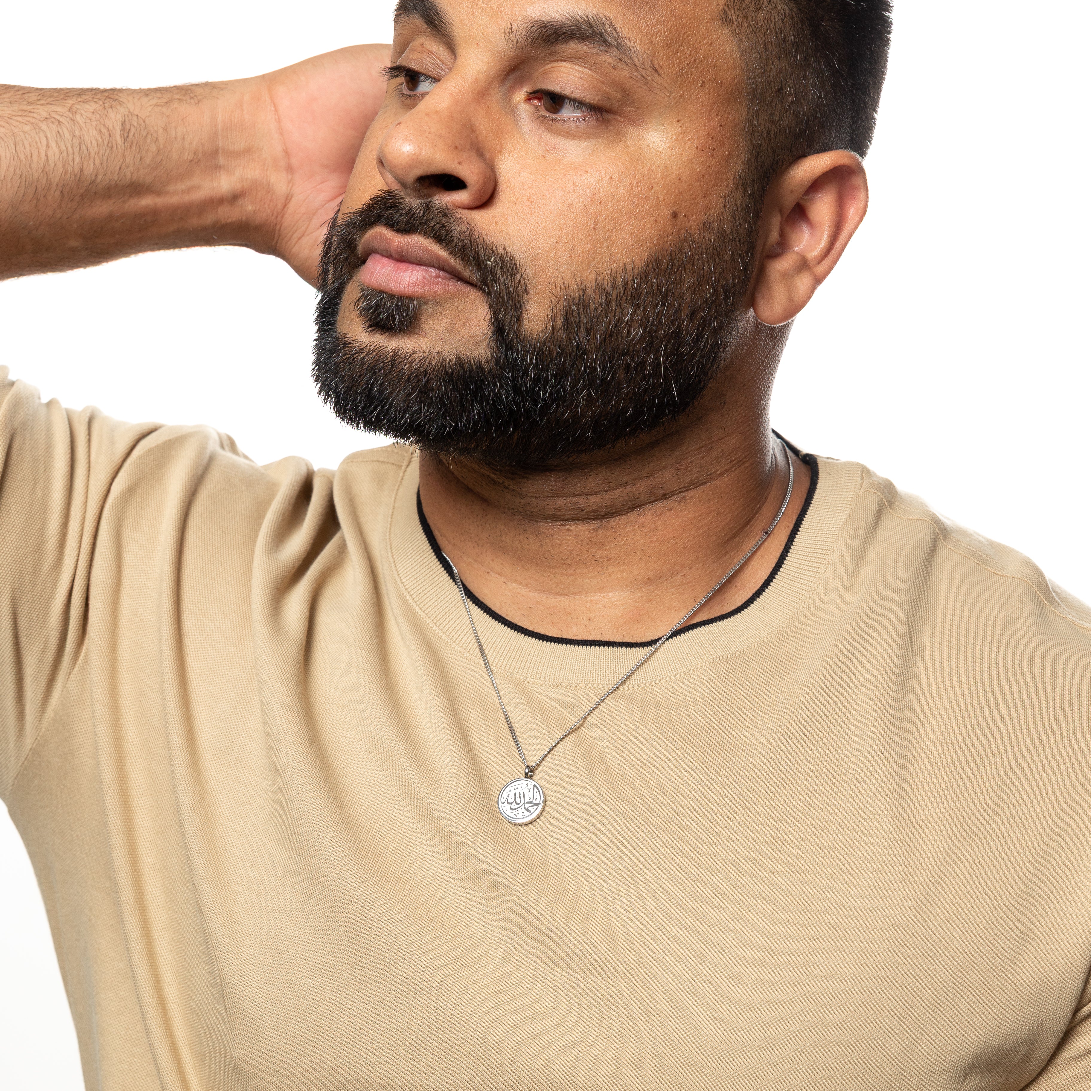 Lifestyle shot of the Alhamdulillah Token Necklace worn by a man, emphasizing its appeal as a daily accessory.
