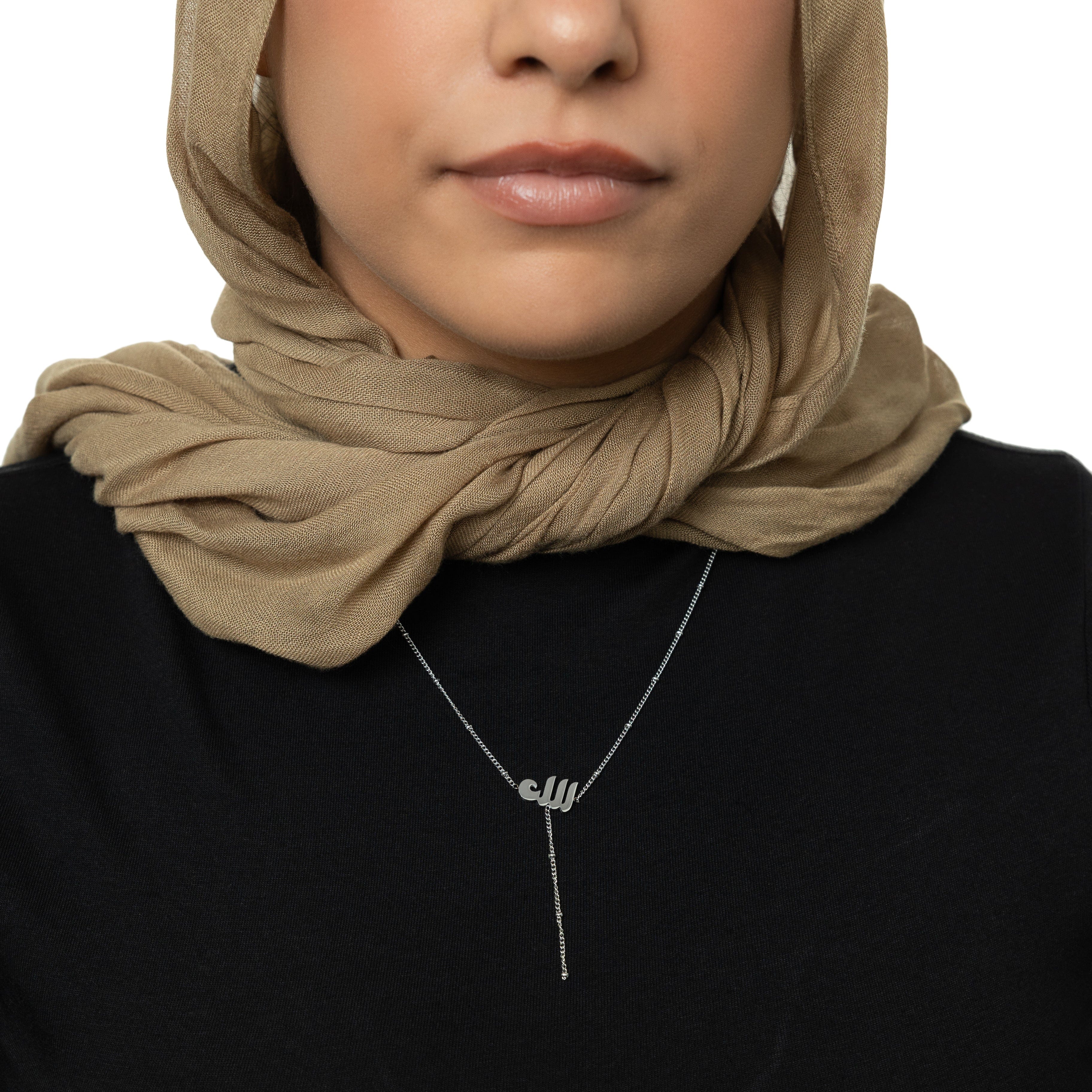 Chic Allah lariat necklace showcased against a soft velvet background.