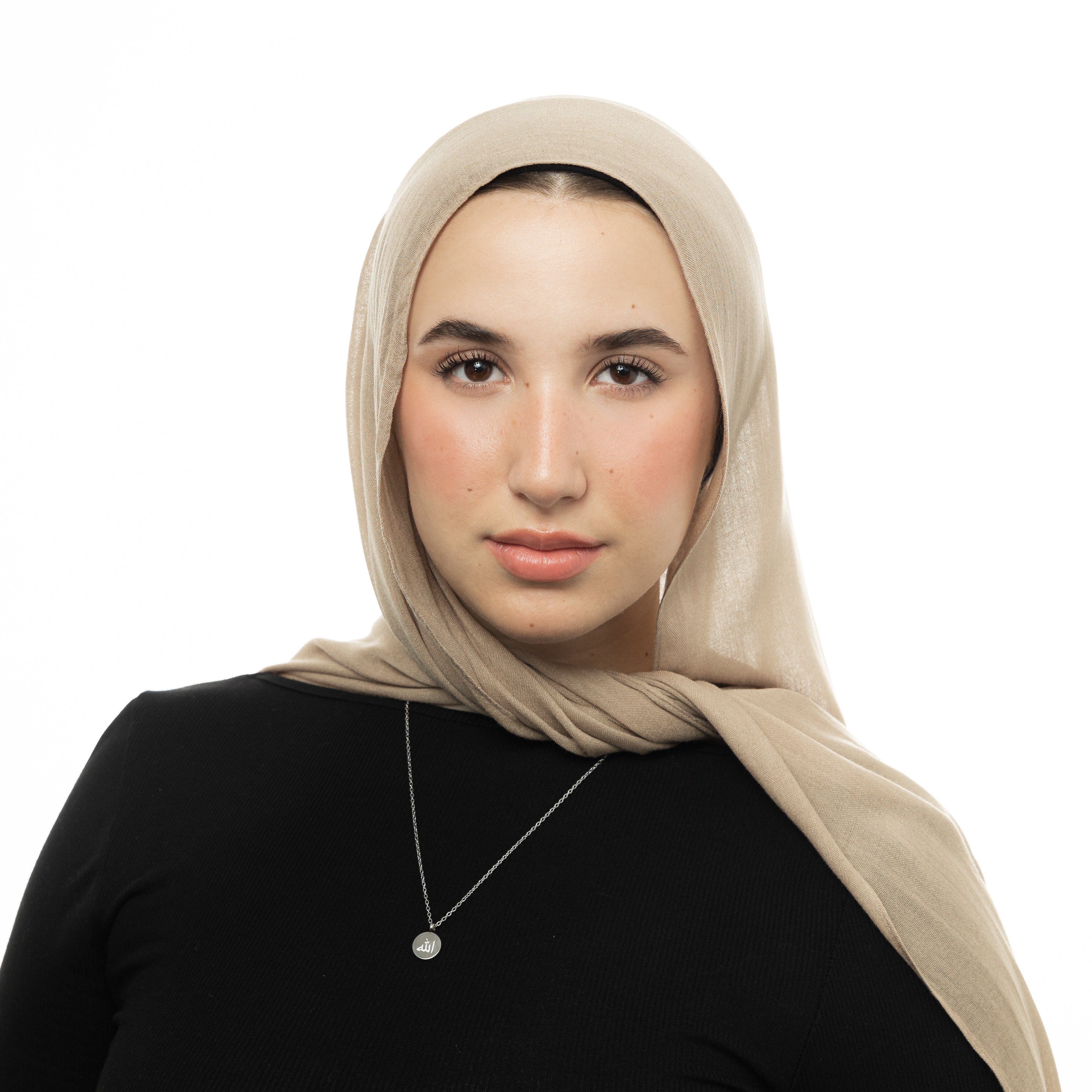 Radiant Allah necklace on a velvet pouch, highlighting its intricate design.
