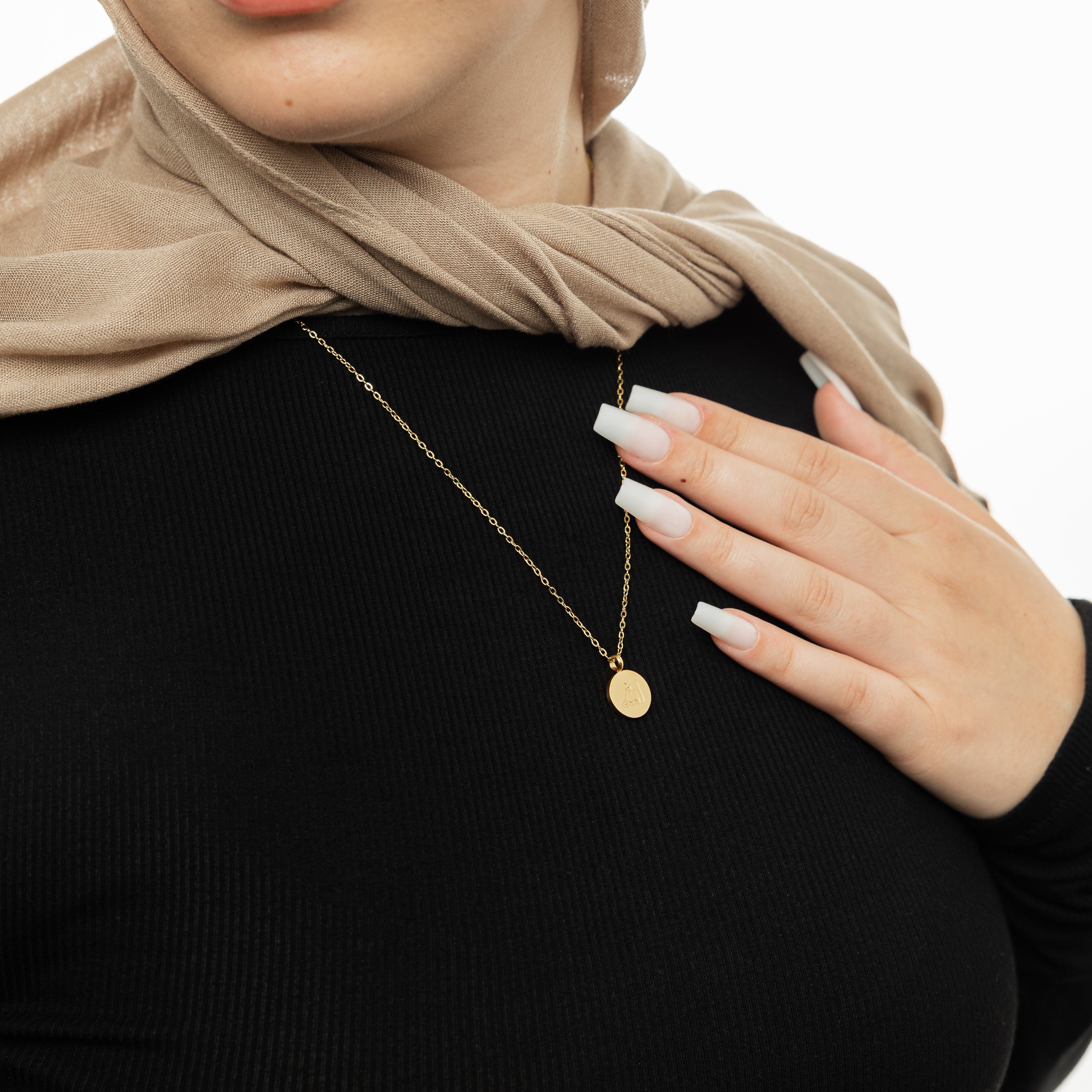 Radiant Allah necklace on a velvet pouch, highlighting its intricate design.