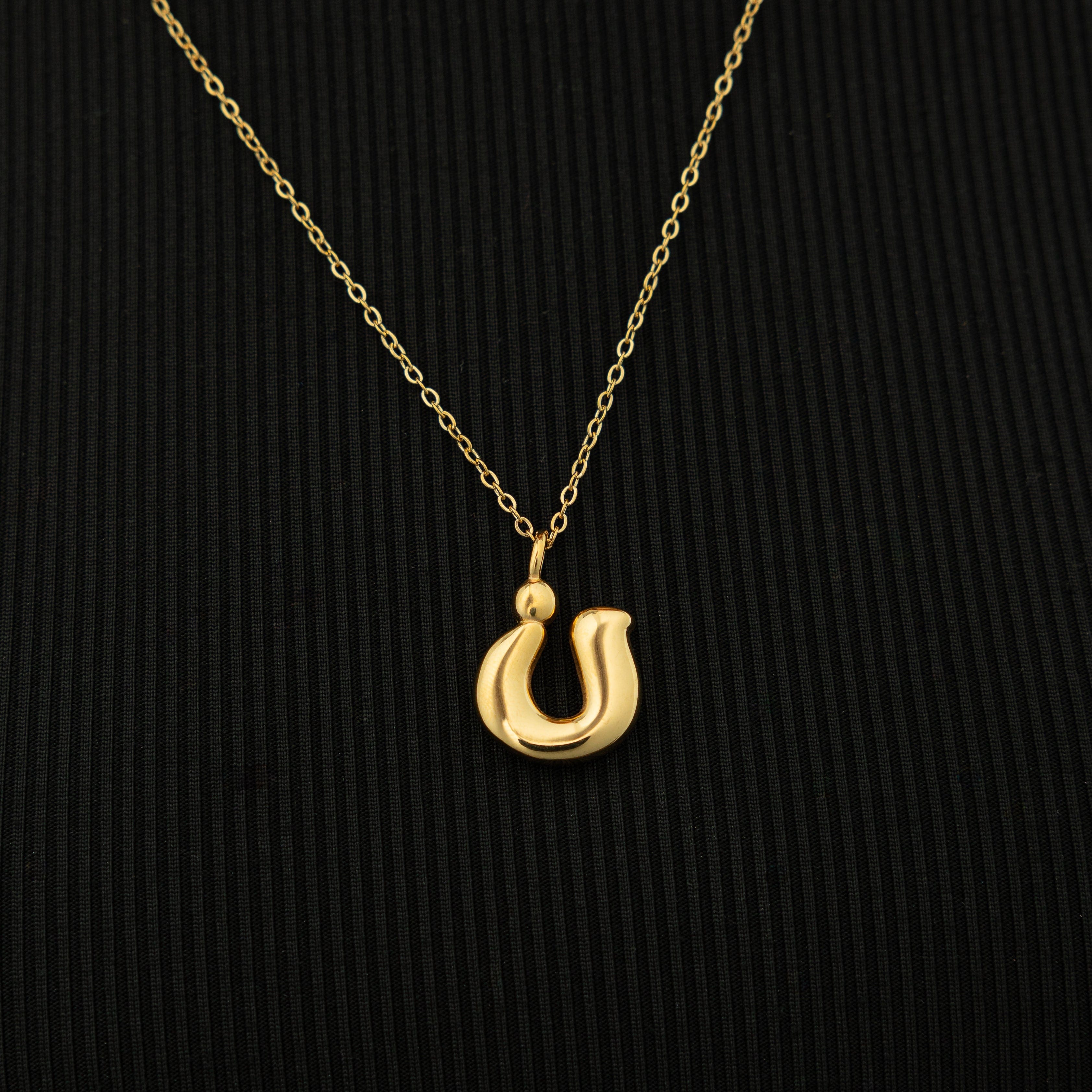 The Arabic bubble letter necklace displayed in a velvet pouch, ready for gift-giving.
