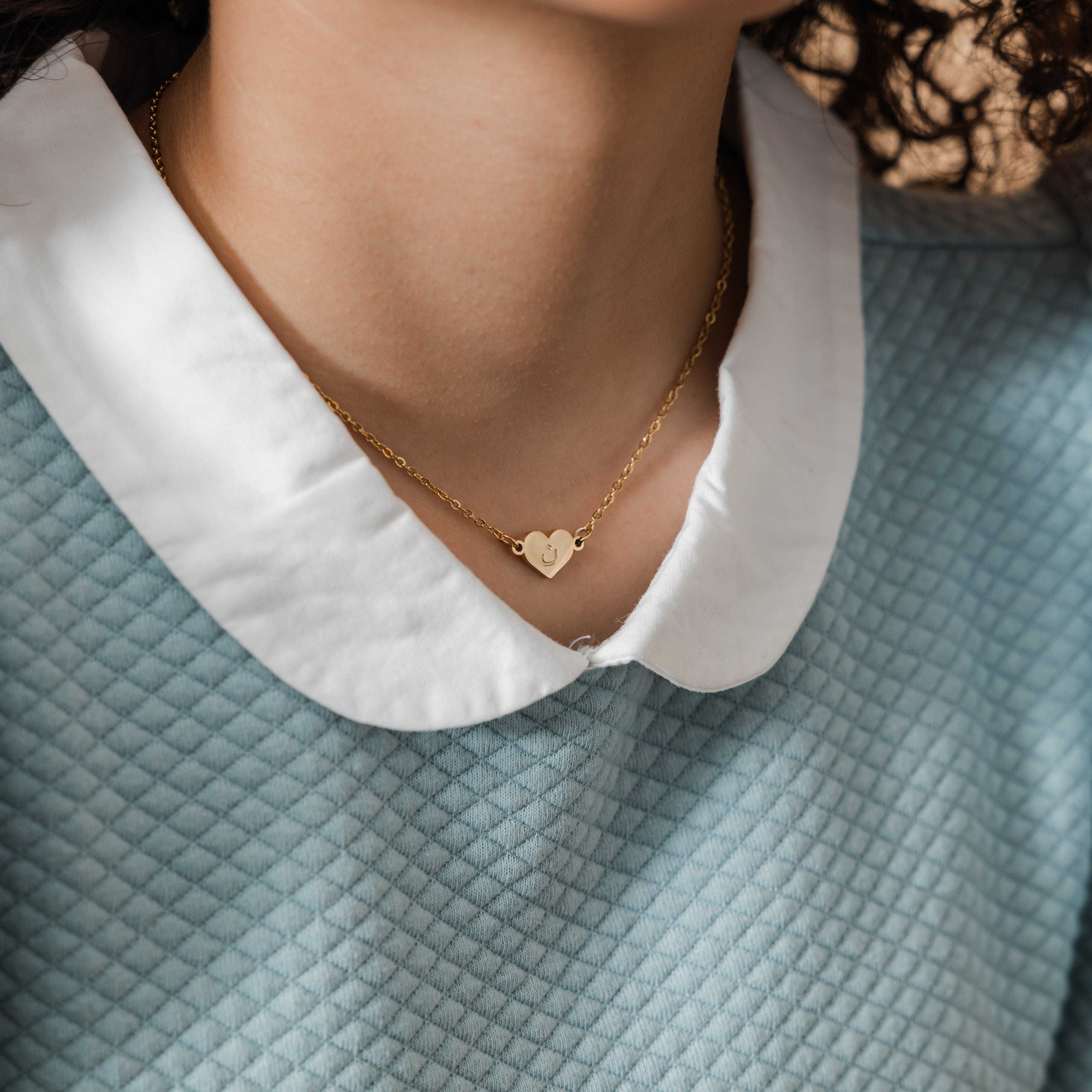 Close-up view of the personalized Arabic letter heart necklace, showcasing its elegant gold finish.