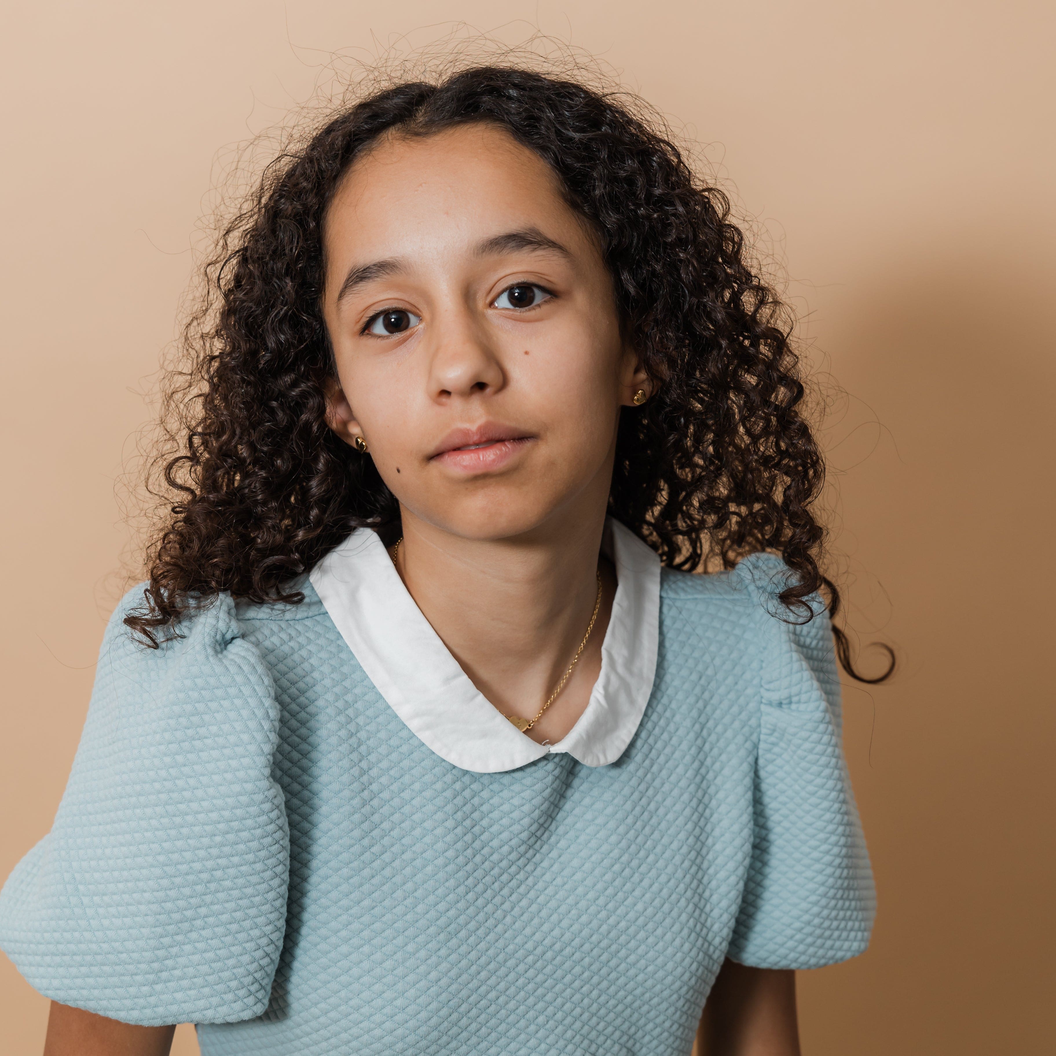 The Arabic letter heart necklace displayed on a young girl, highlighting its delicate design.