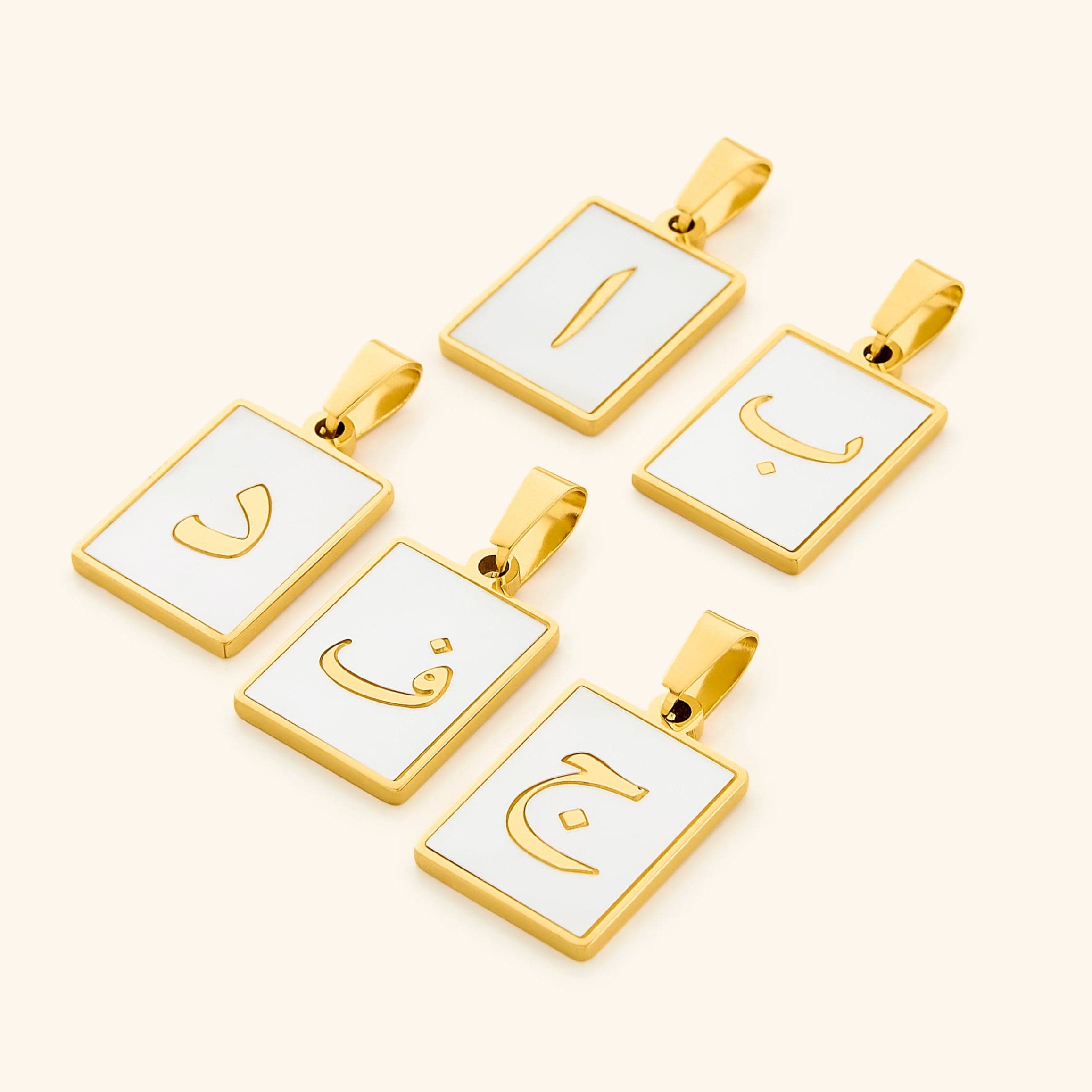 Elegant Arabic letter charm displayed on a shimmering pearl backdrop, showcasing its intricate design.