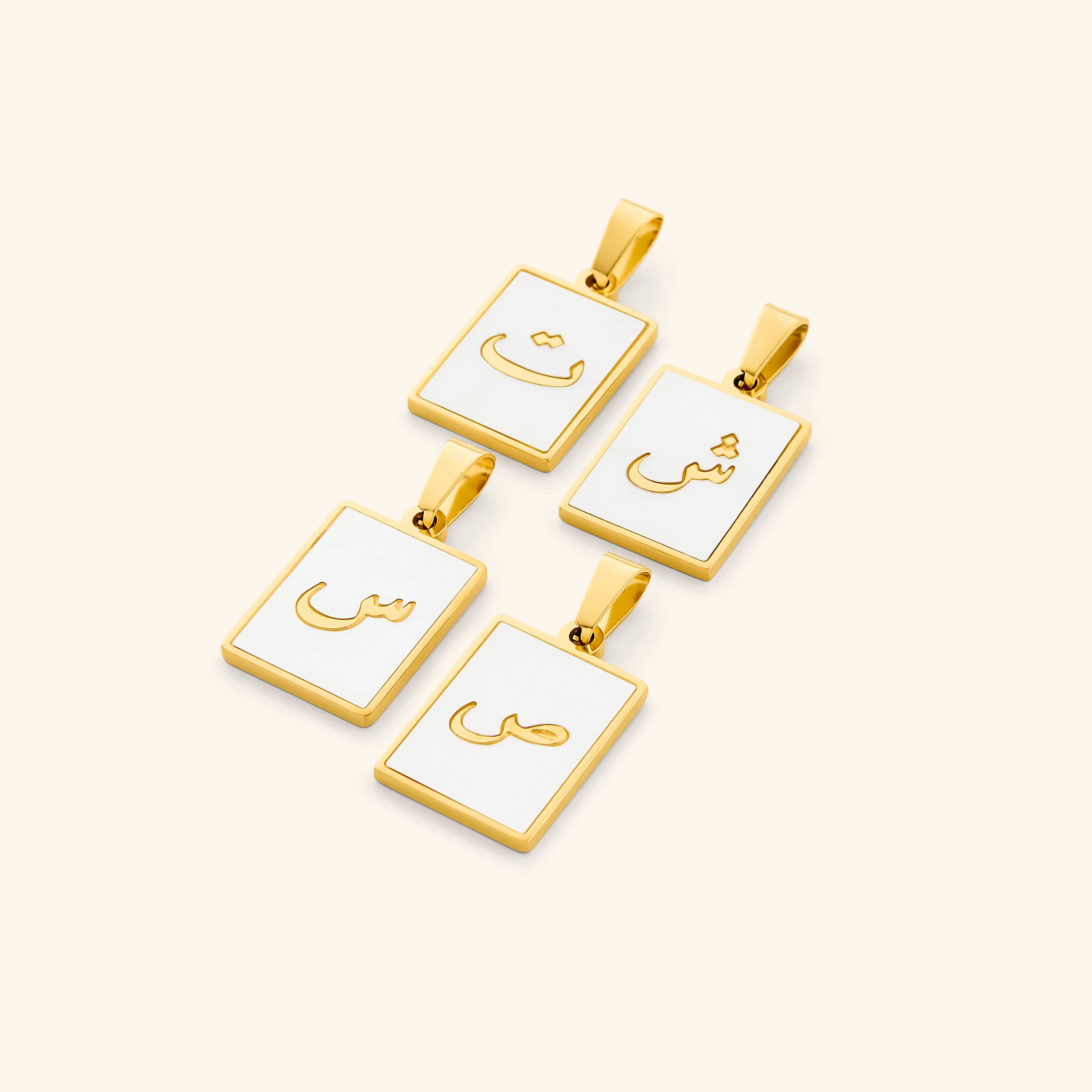 Elegant Arabic letter charm displayed on a shimmering pearl backdrop, showcasing its intricate design.