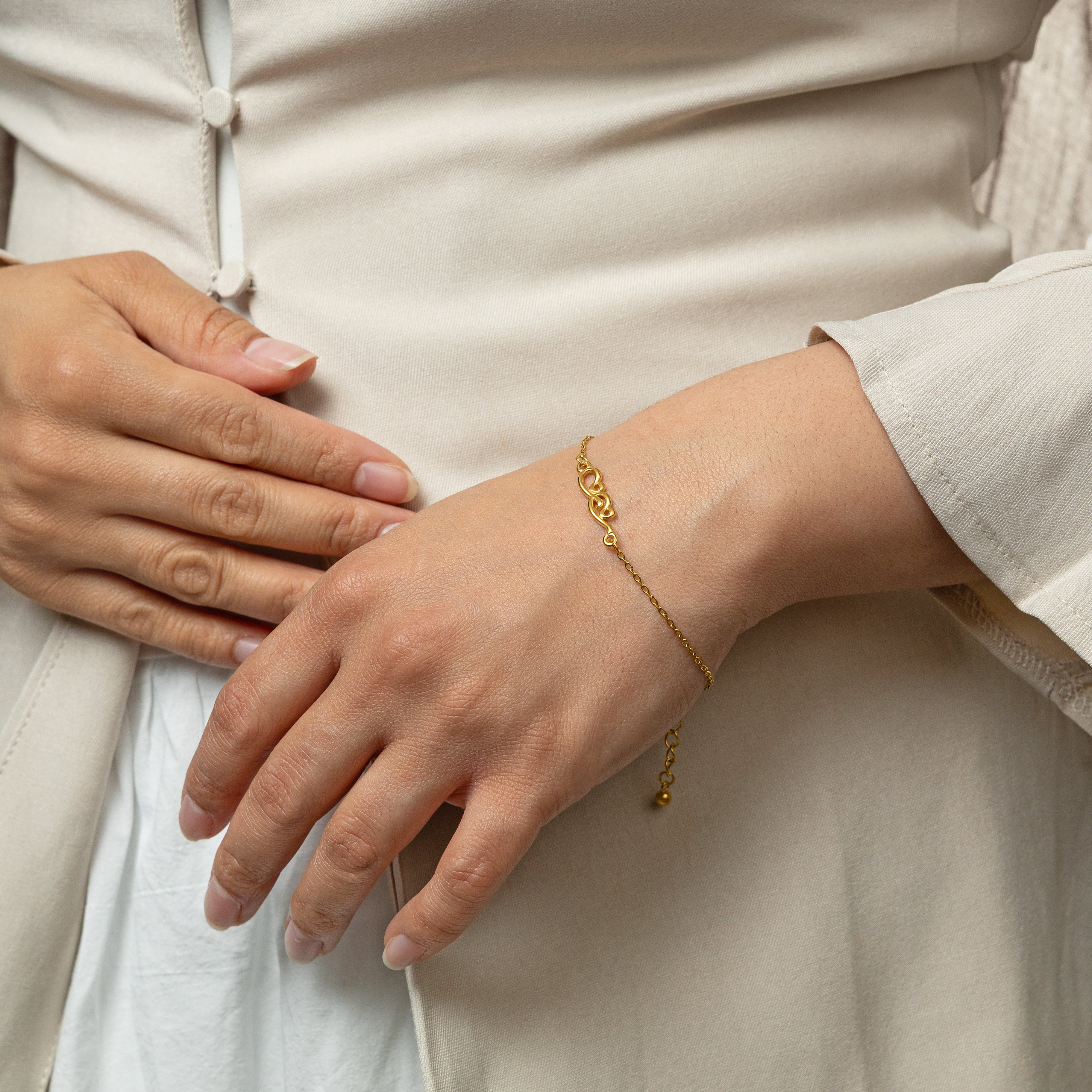 Model wearing the gold Arabic calligraphy bracelet, highlighting its beauty