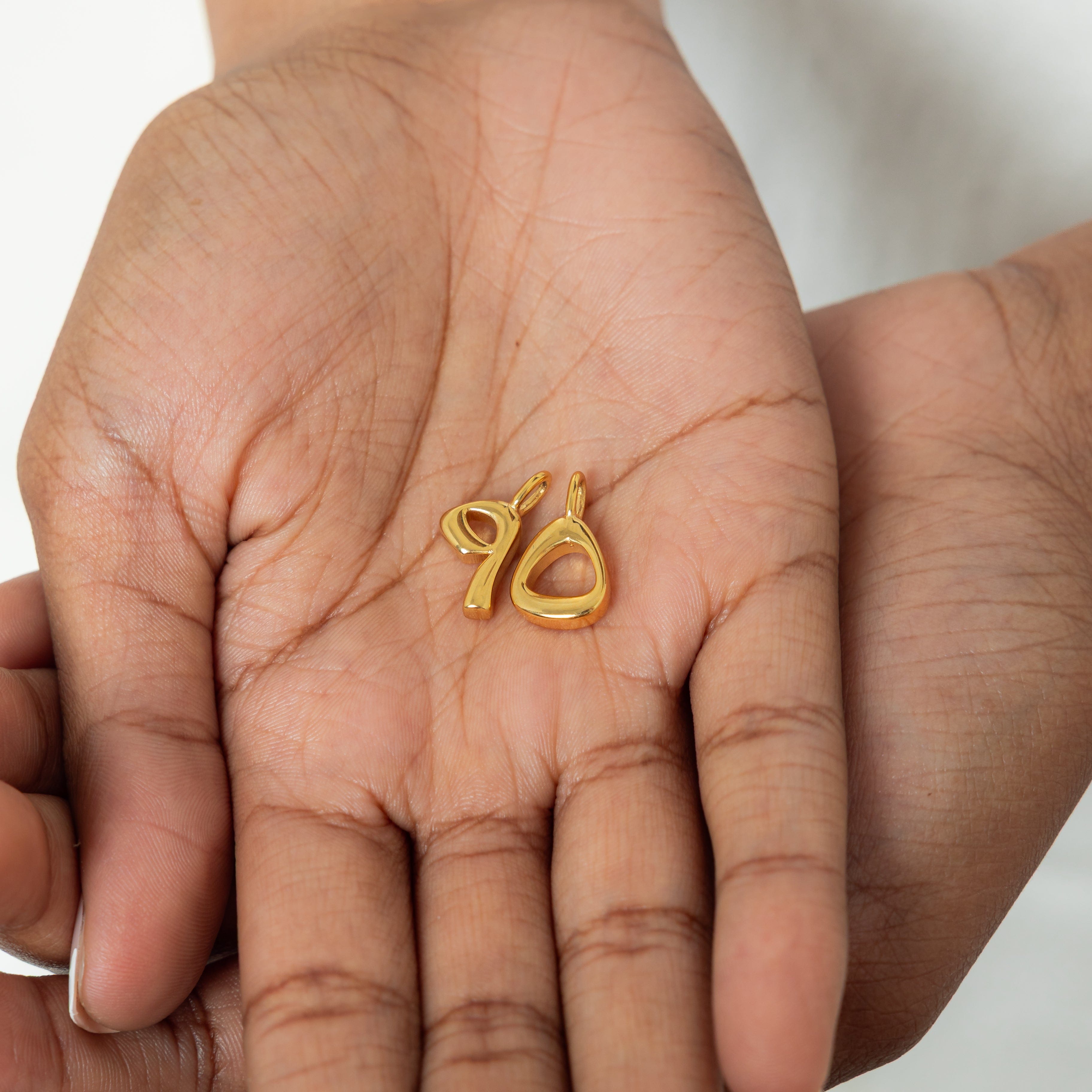 Close-up of personalized number charms with a velvet pouch, perfect for gifting.