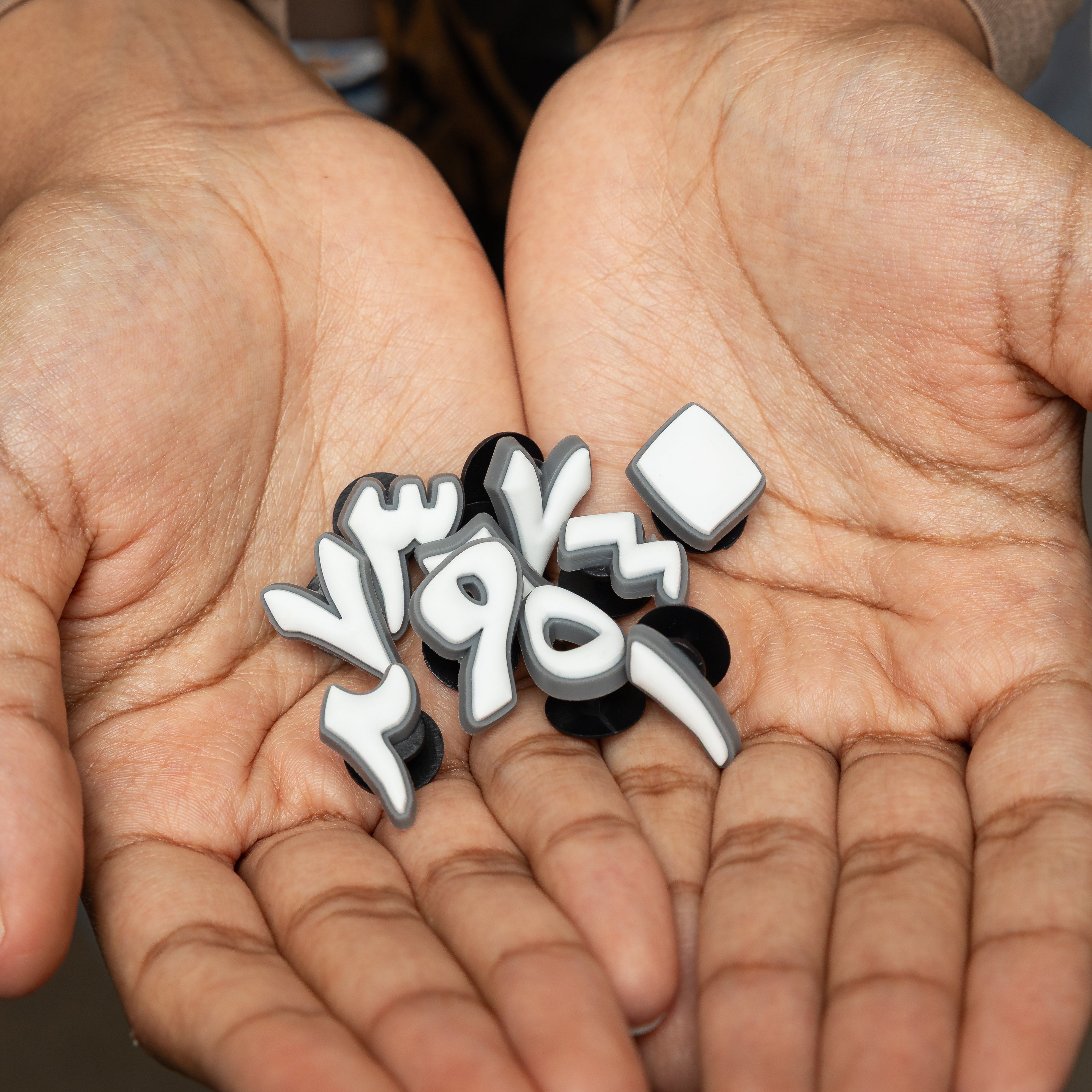 Close-up of unique Arabic numeral charms for crafts, featuring bold designs.