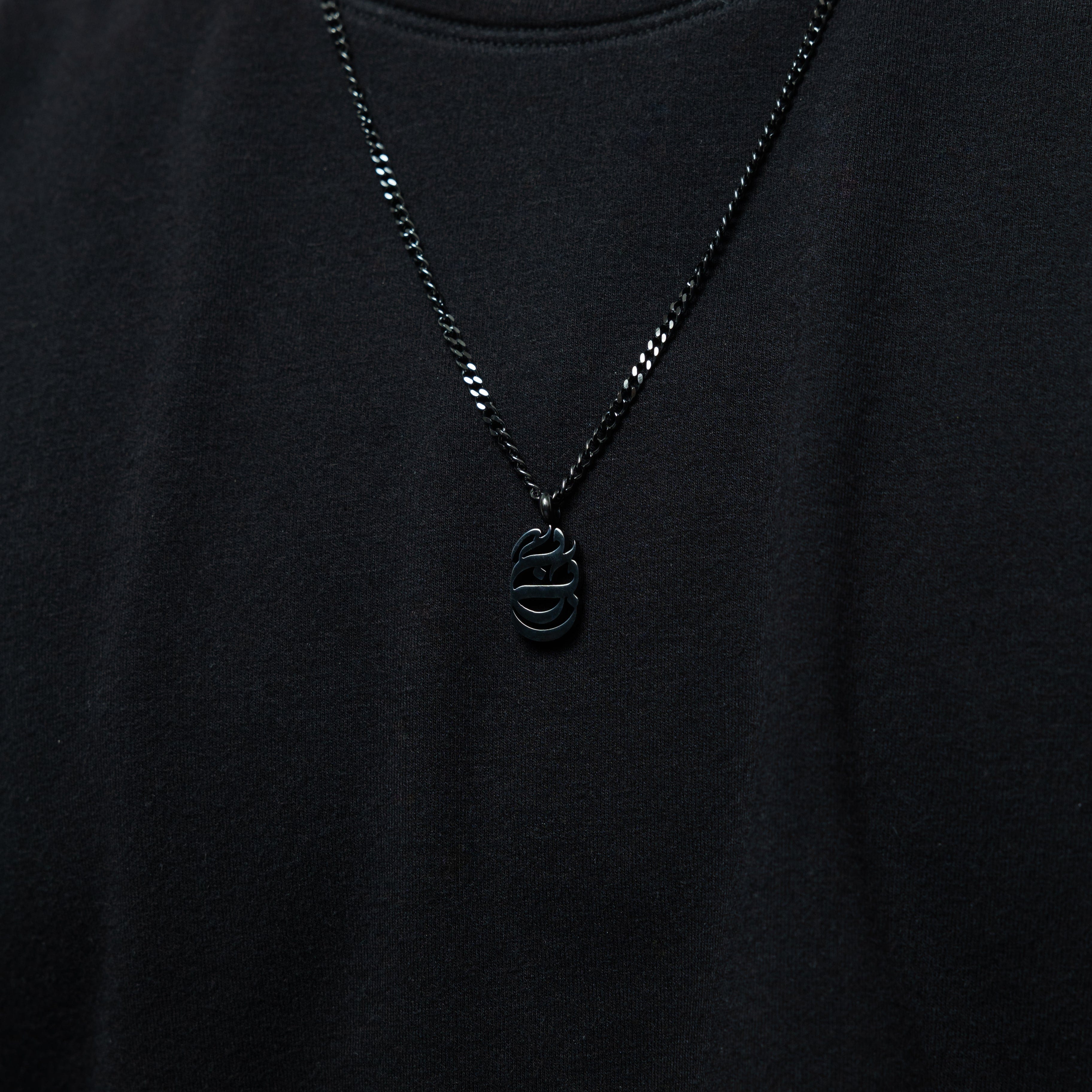 Close-up of the Baba Oval Necklace showcasing the intricate Arabic calligraphy