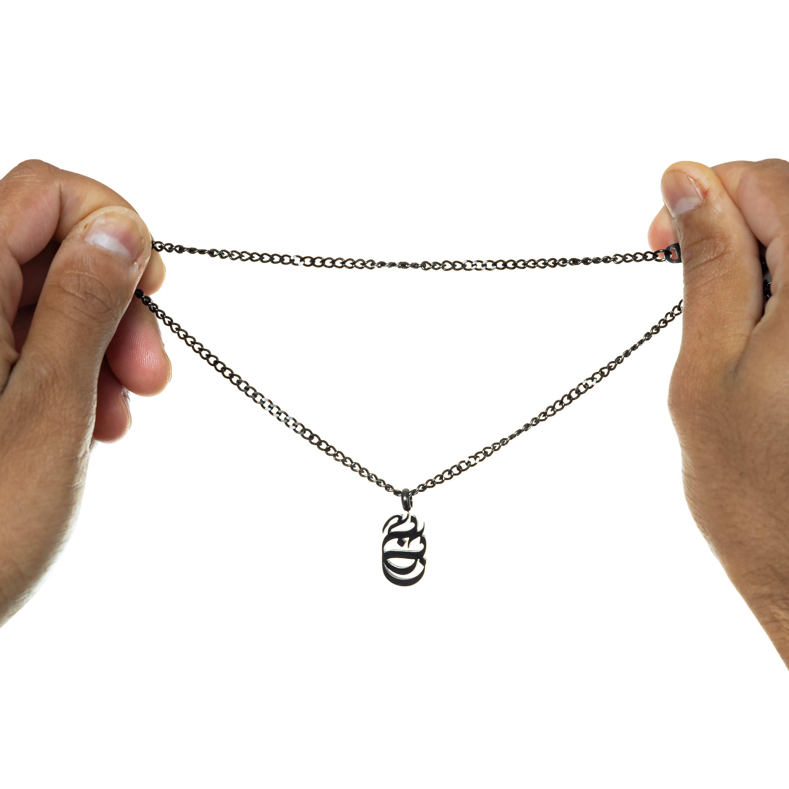 Baba Oval Arabic Calligraphy Necklace displayed on a wooden table