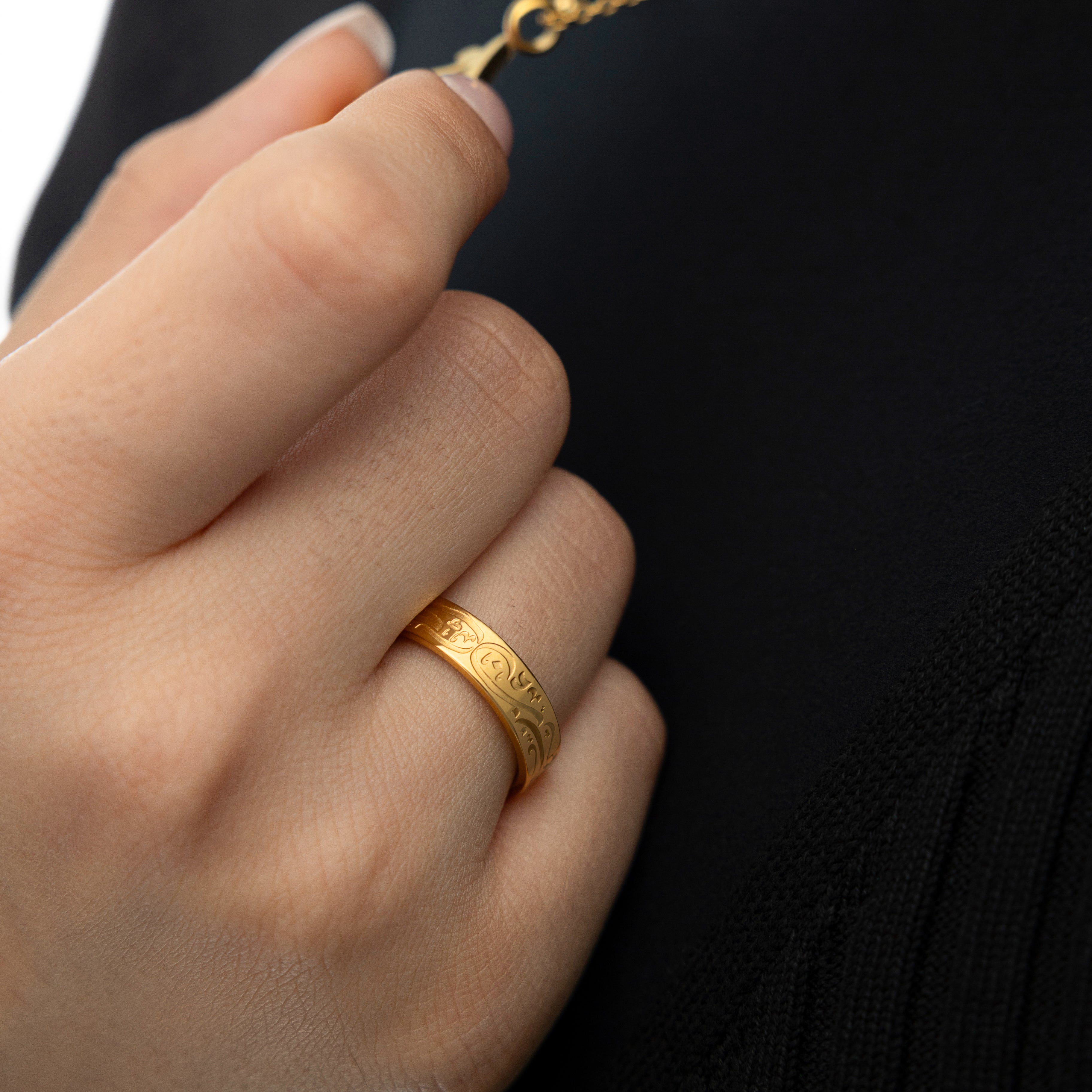 Elegant presentation of the calligraphy ring in a velvet pouch, highlighting its gold plating.