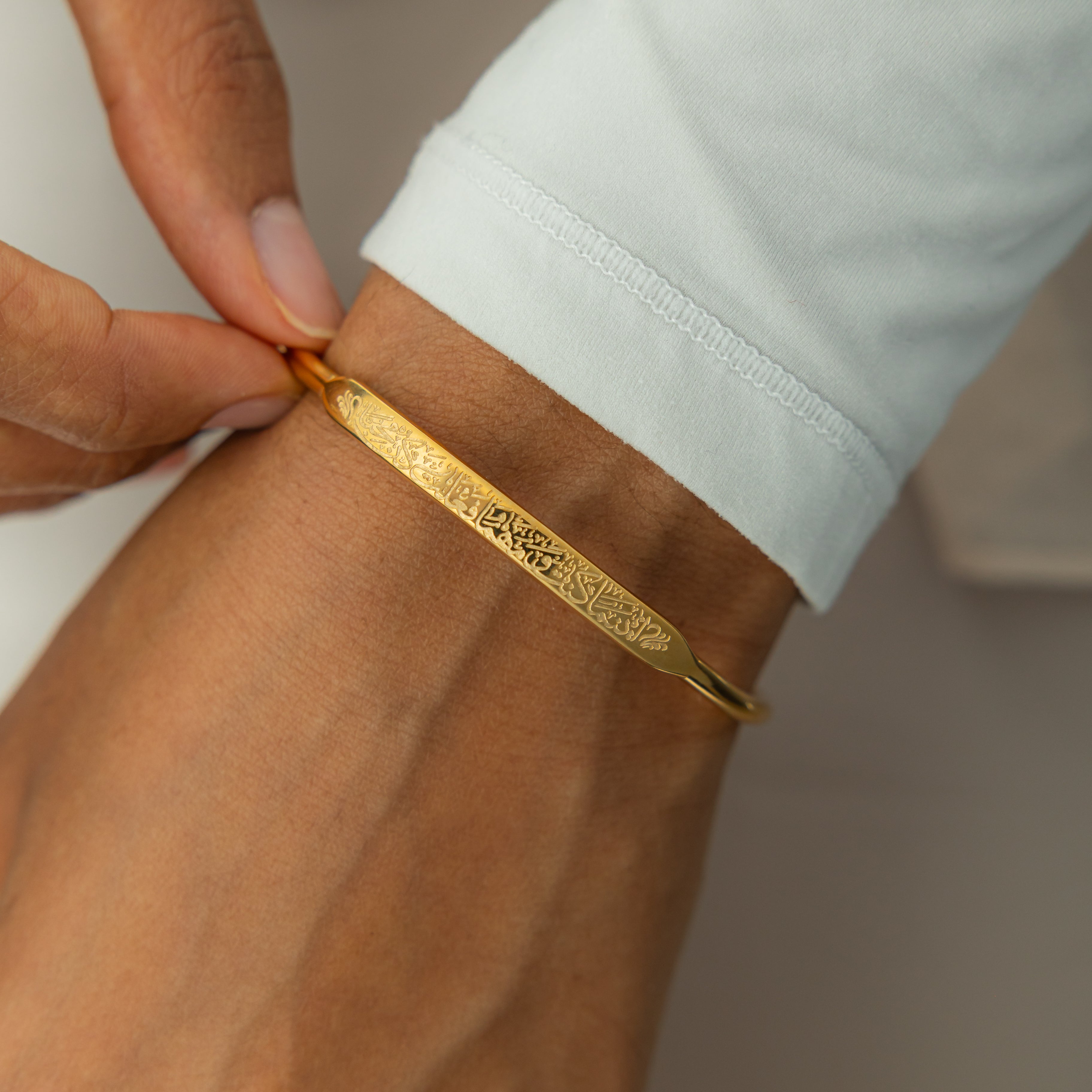 Model wearing the hypoallergenic gold bangle with quote in natural light