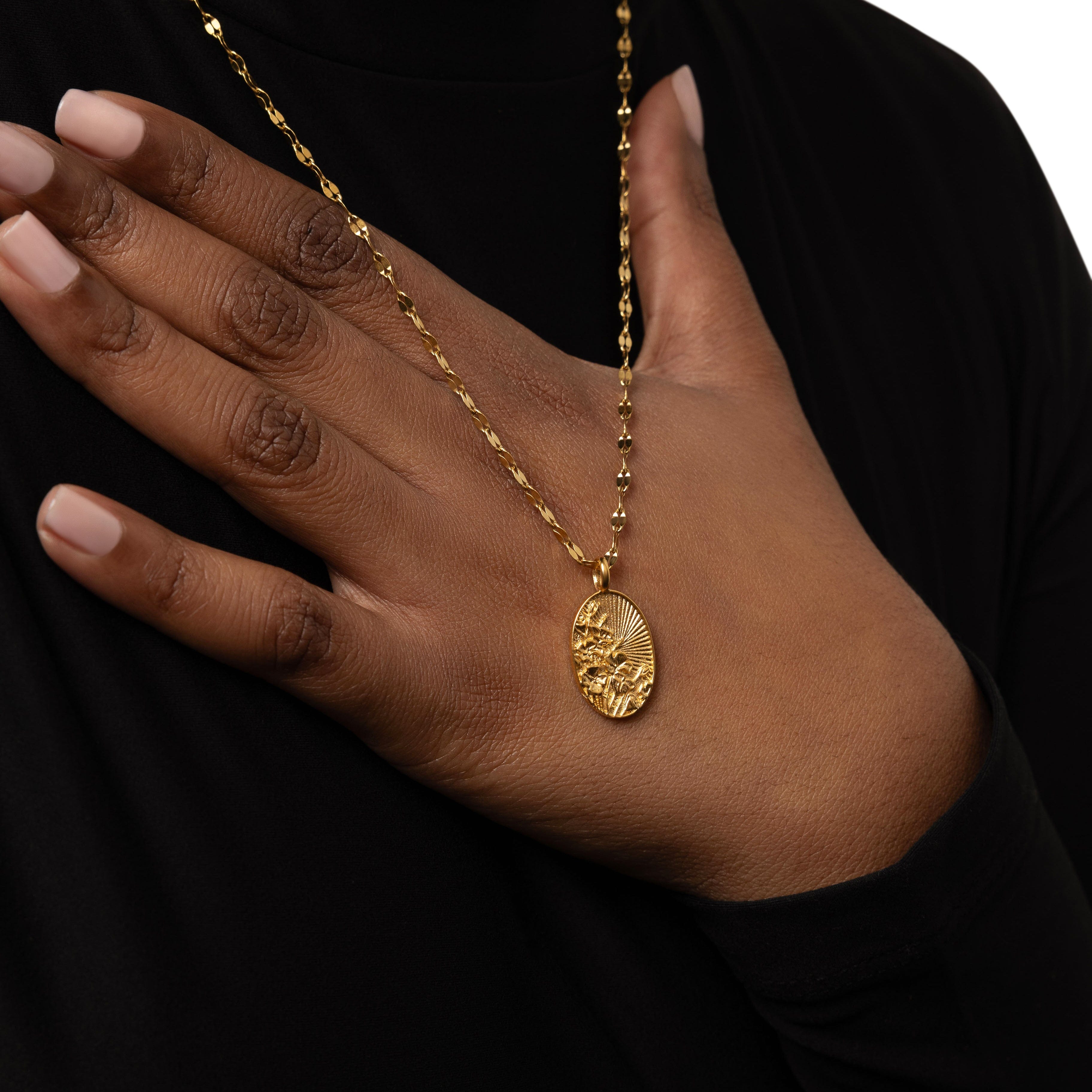 Close-up of the radiant Palestine poppy necklace highlighting its floral design and gold finish.