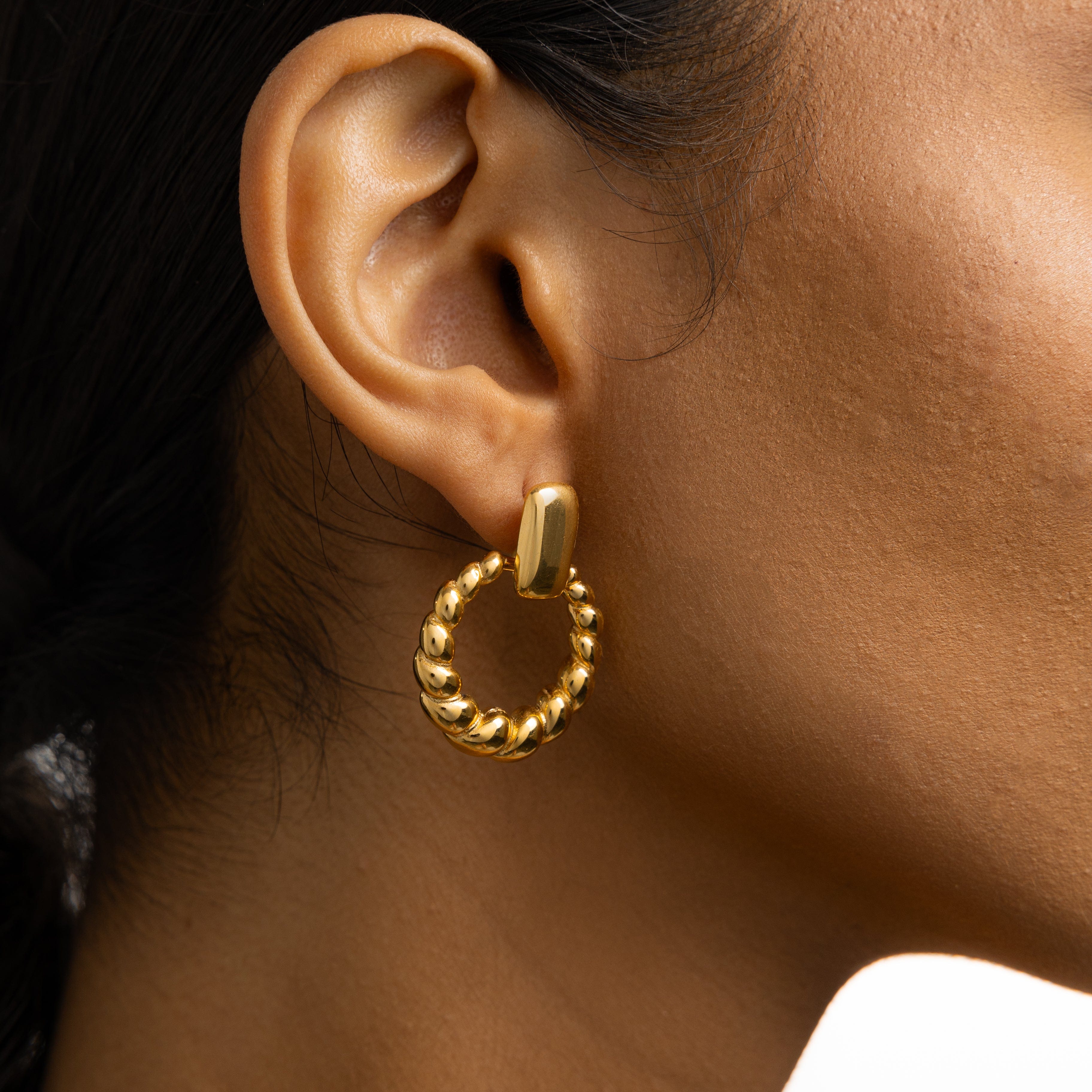 Close-up of stylish waterproof hoop earrings, highlighting the intricate braid detail.