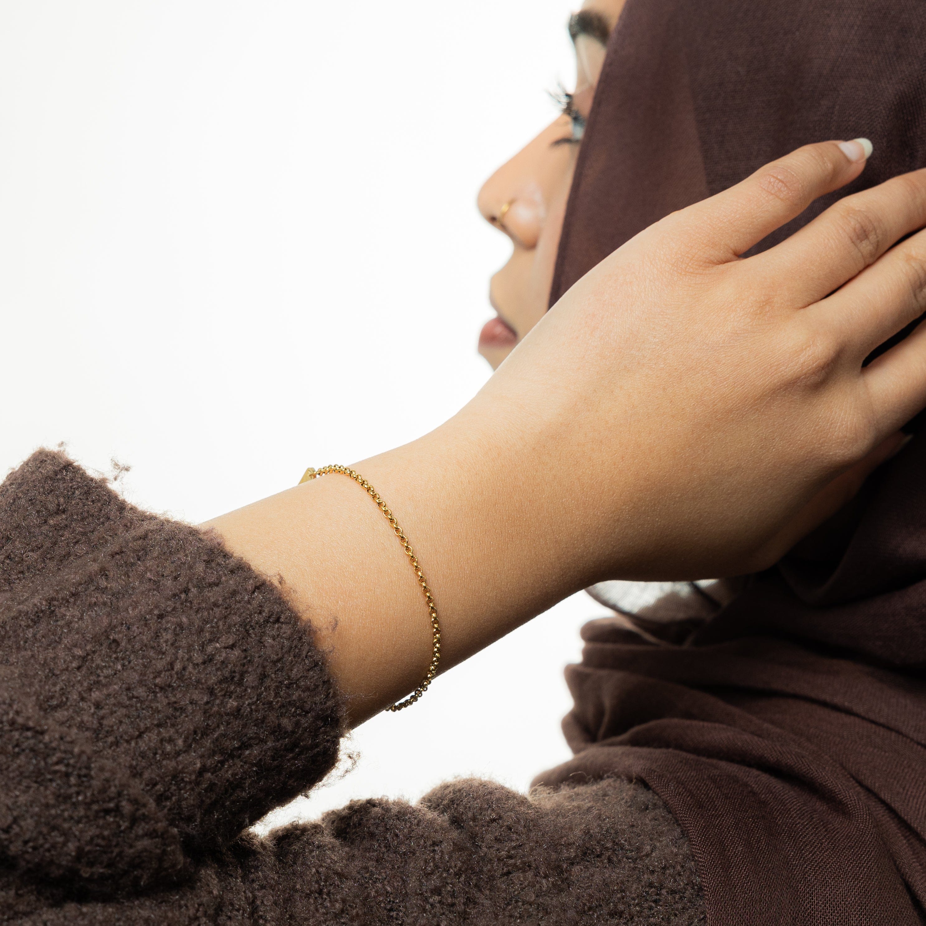 Elegant Invisible Box Bracelet displayed on a velvet pouch, highlighting its gold finish and delicate chain design.