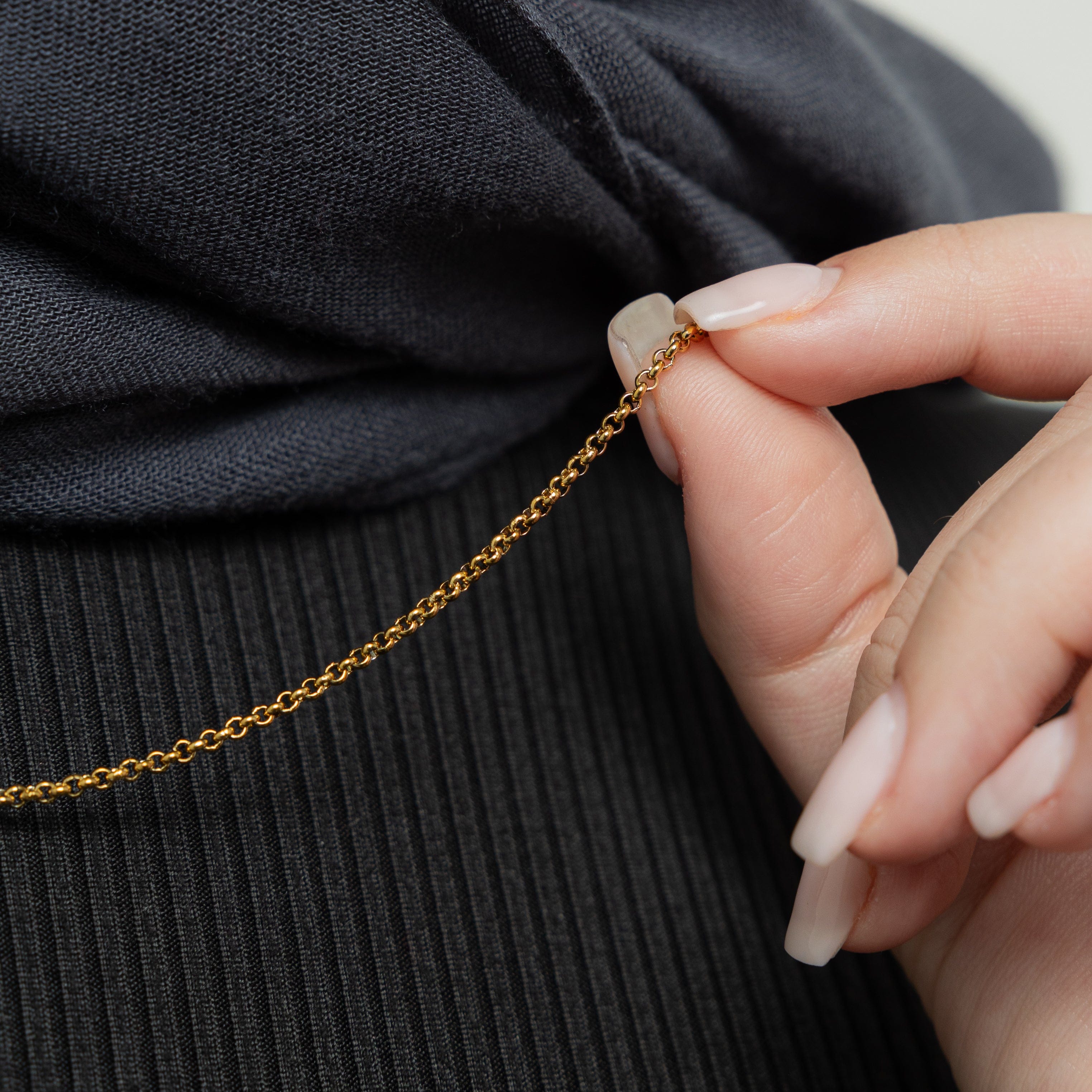 The bracelet styled on a wrist with other dainty hypoallergenic jewelry pieces for a stackable, everyday look.