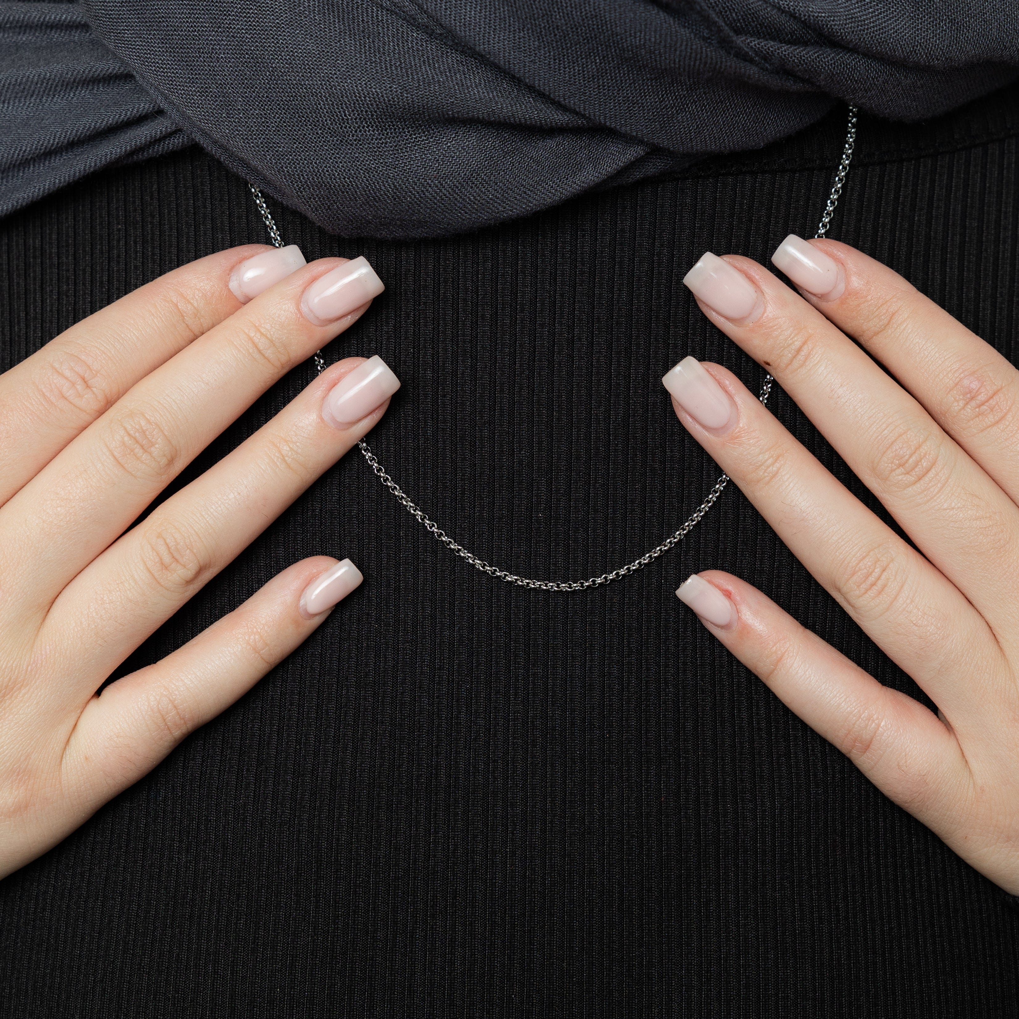 Close-up of the 18k gold box chain bracelet resting on a velvet pouch, showcasing minimalist design and hypoallergenic metal.