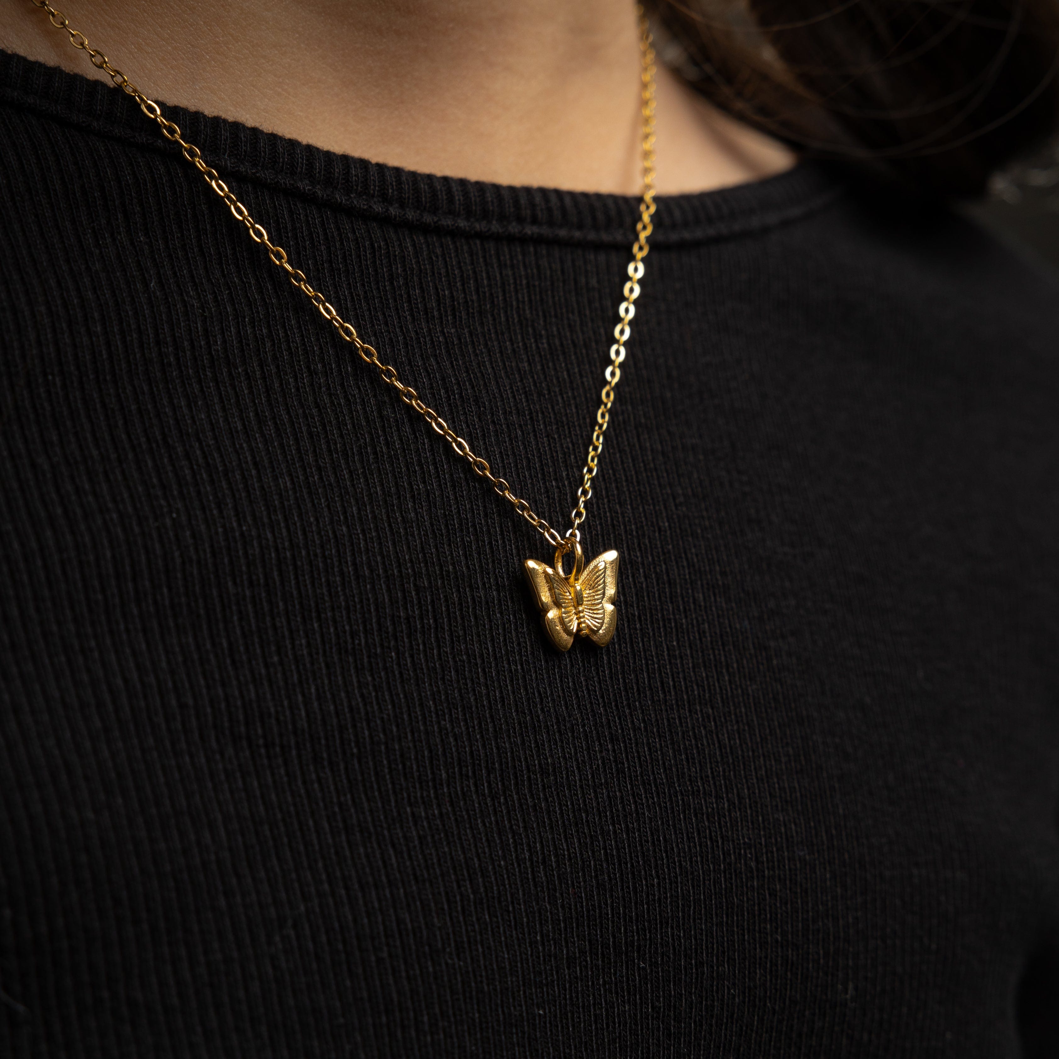 A little girl wearing the butterfly necklace with a bright smile, perfect for any outfit.
