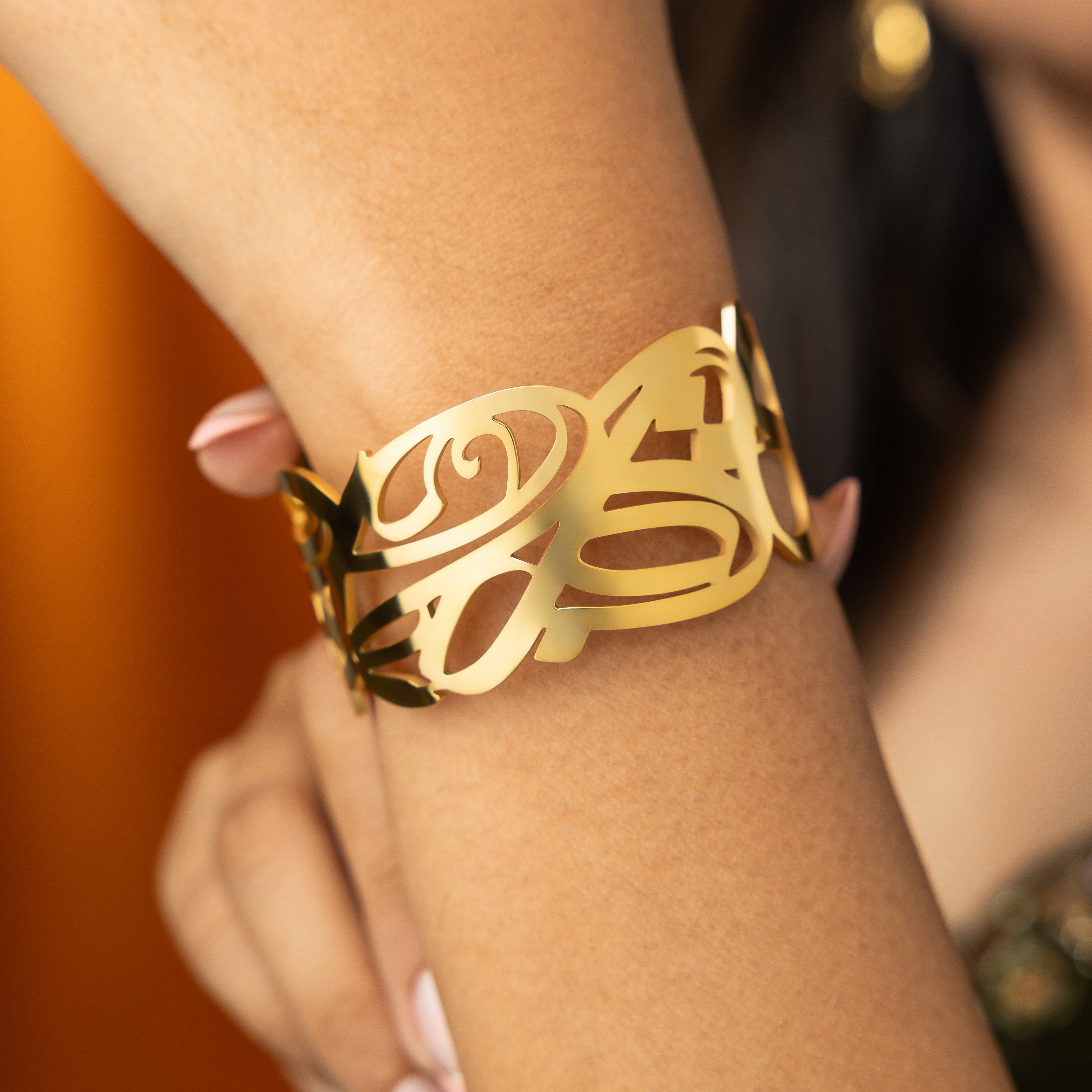 Elegant gold cuff bracelet displayed in a Nominal velvet pouch, ideal for gifting.