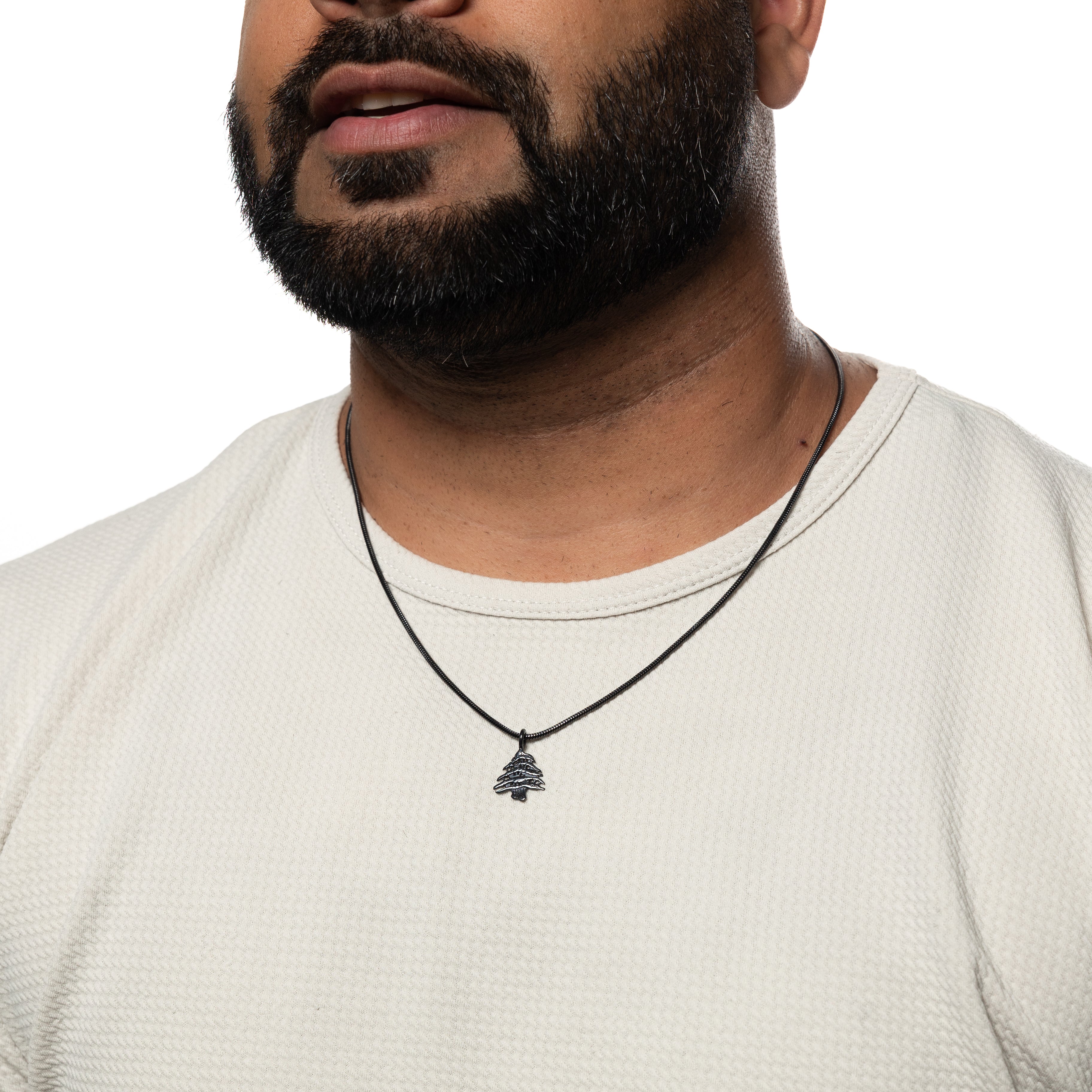 Cedar of Lebanon mens necklace laid flat on a velvet pouch, perfect for gifting or personal use.