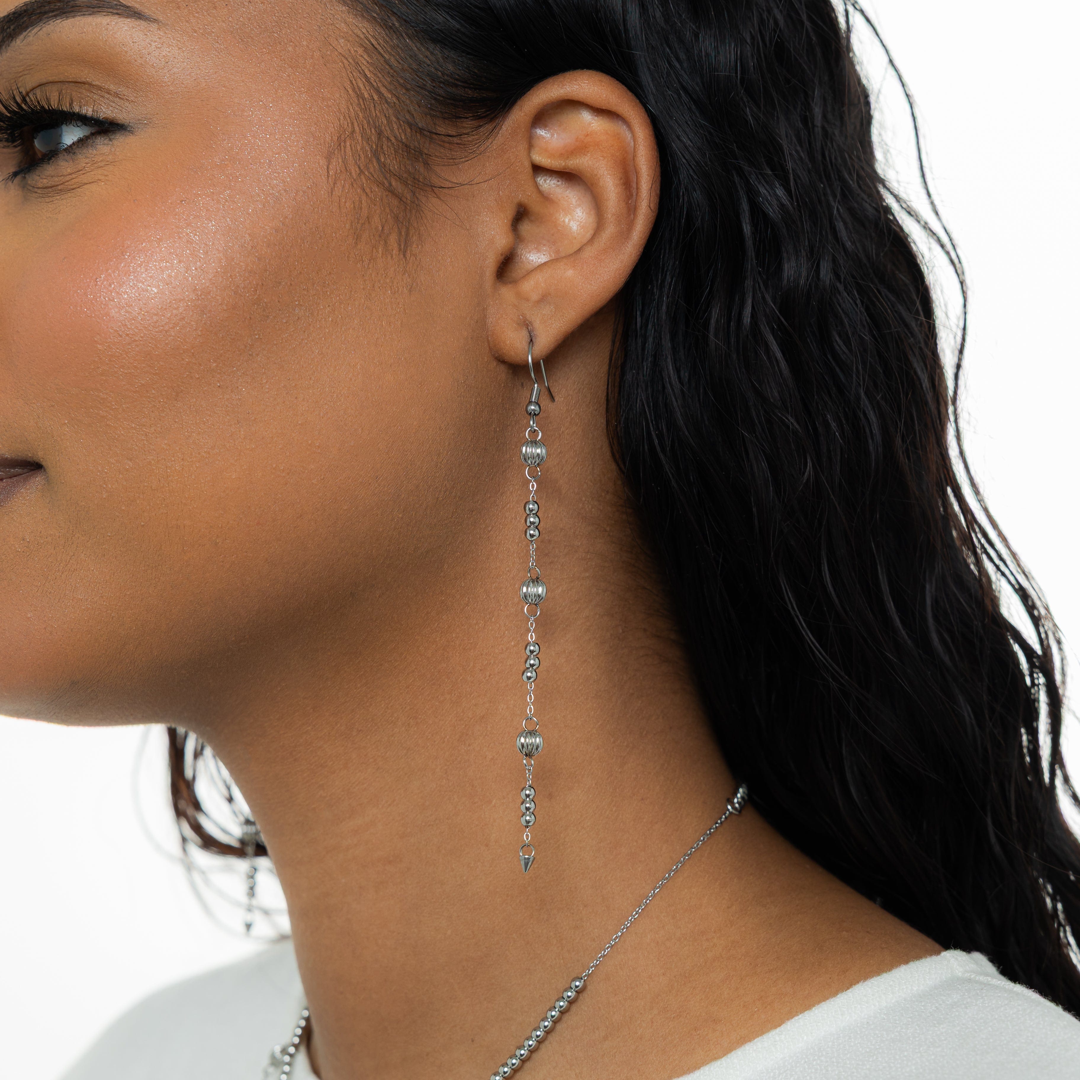 Model wearing Celestial Glow Dangle Earrings at a festive event, showcasing their elegant design.