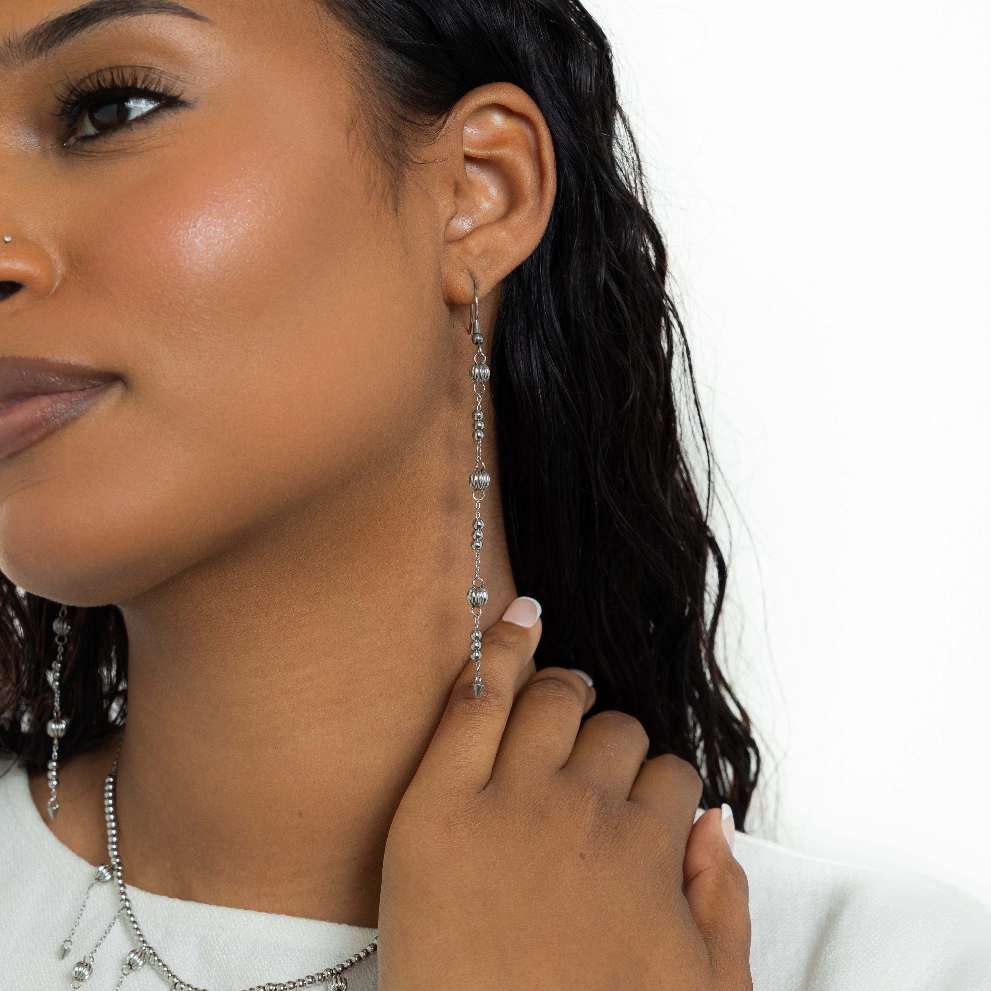 Celestial Glow Dangle Earrings displaying their vibrant shine against a velvet background.