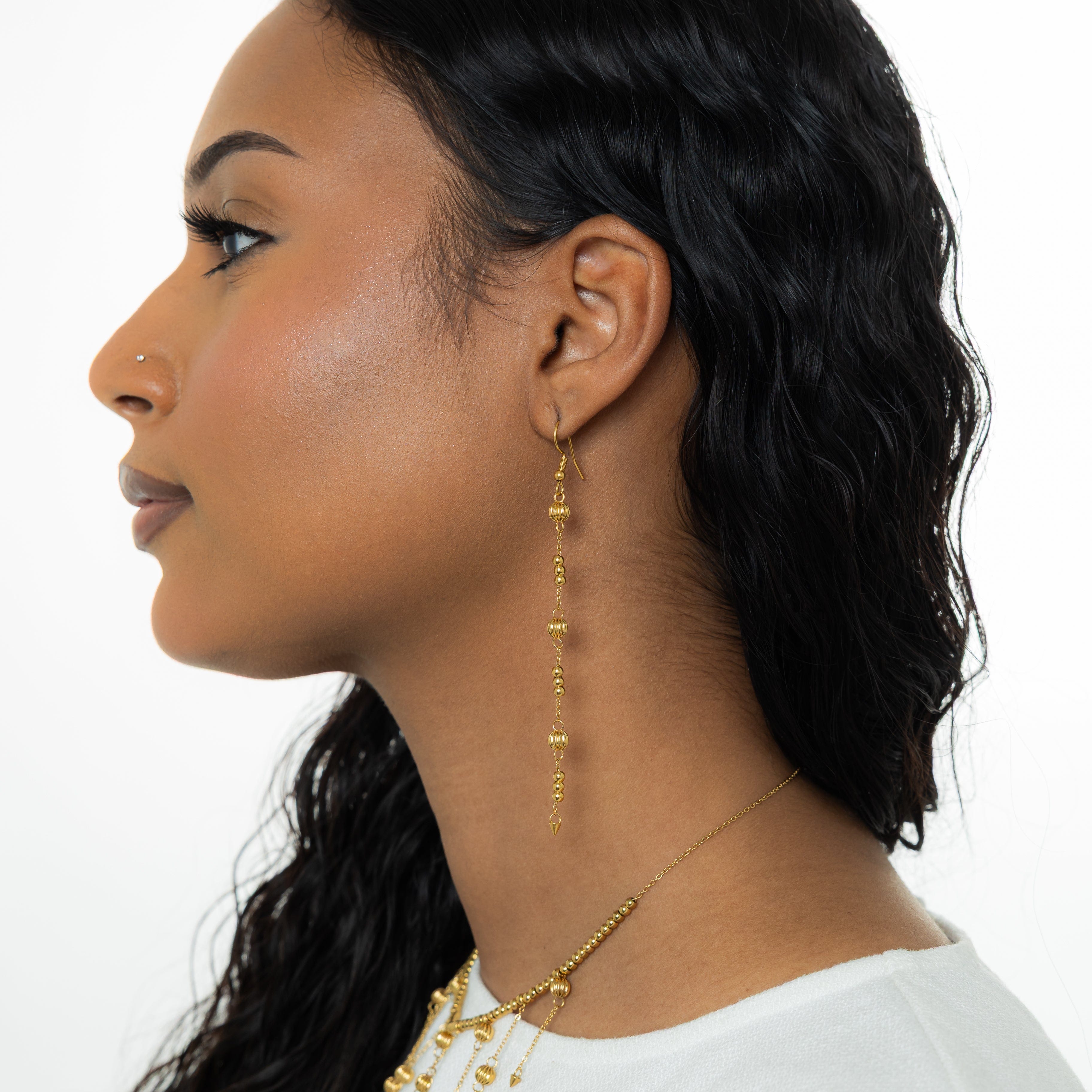 Celestial Glow Dangle Earrings displaying their vibrant shine against a velvet background.