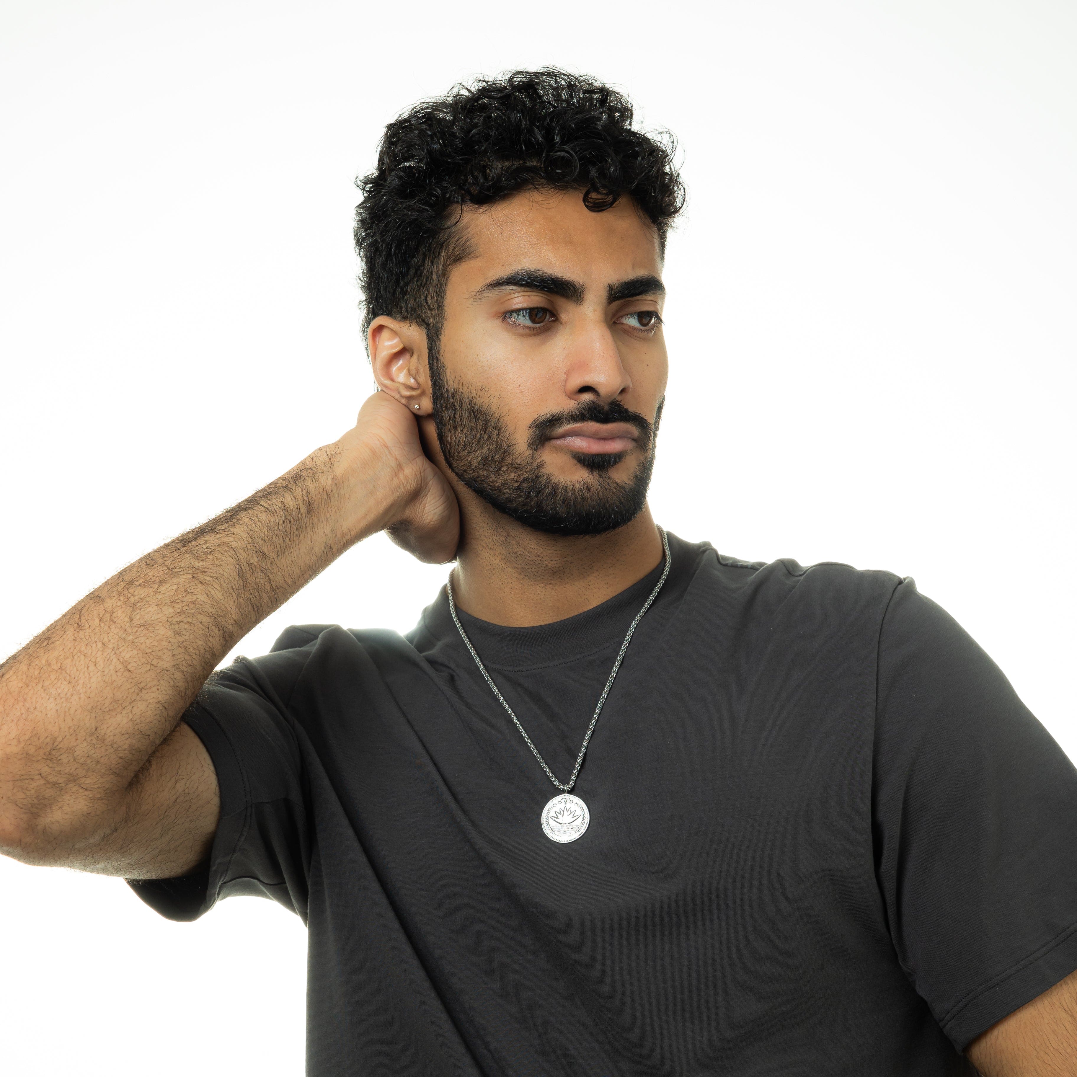 Lifestyle shot of a man wearing the premium mens coin necklace, styled with casual attire.