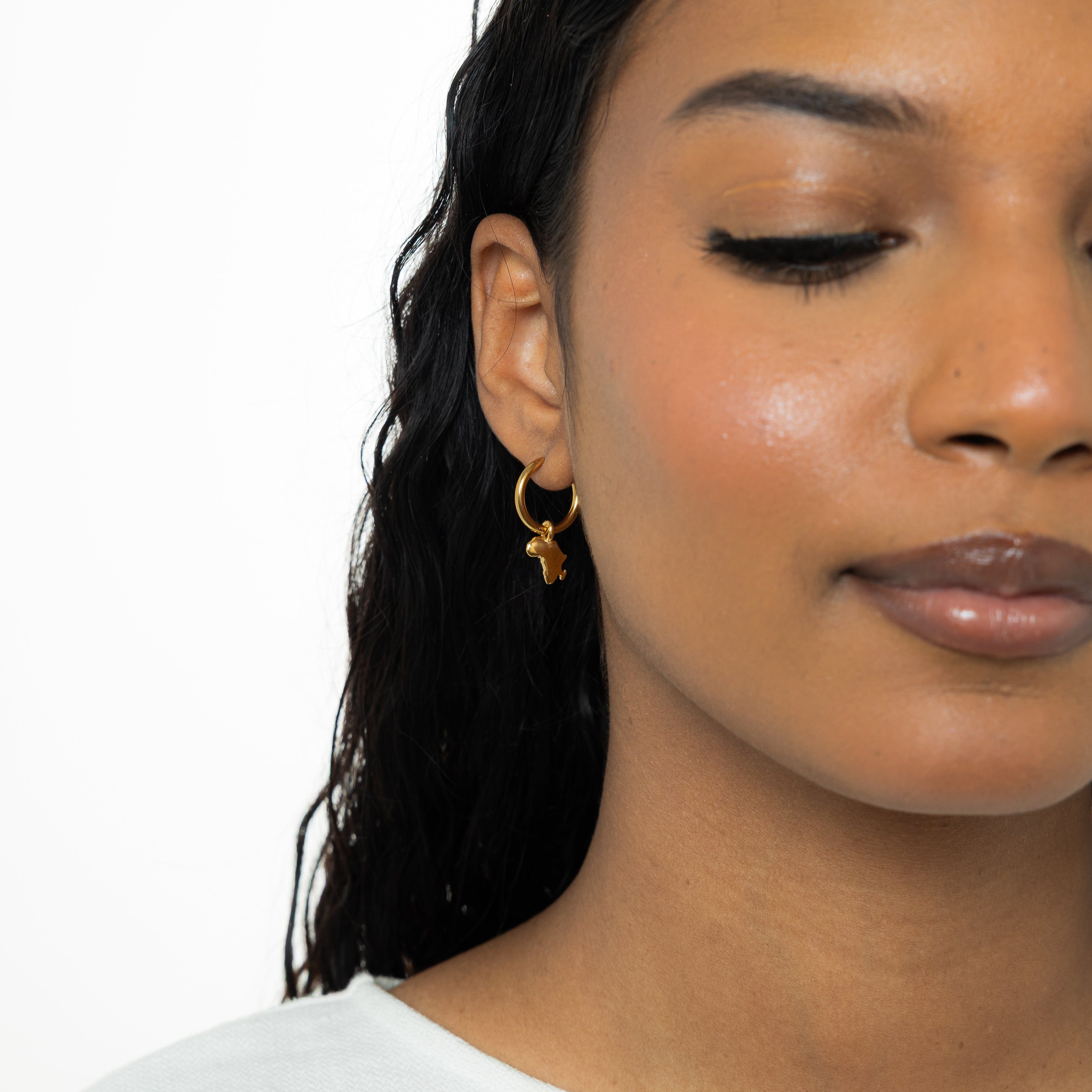 Close-up of personalized country map gold hoops showcasing their intricate design.
