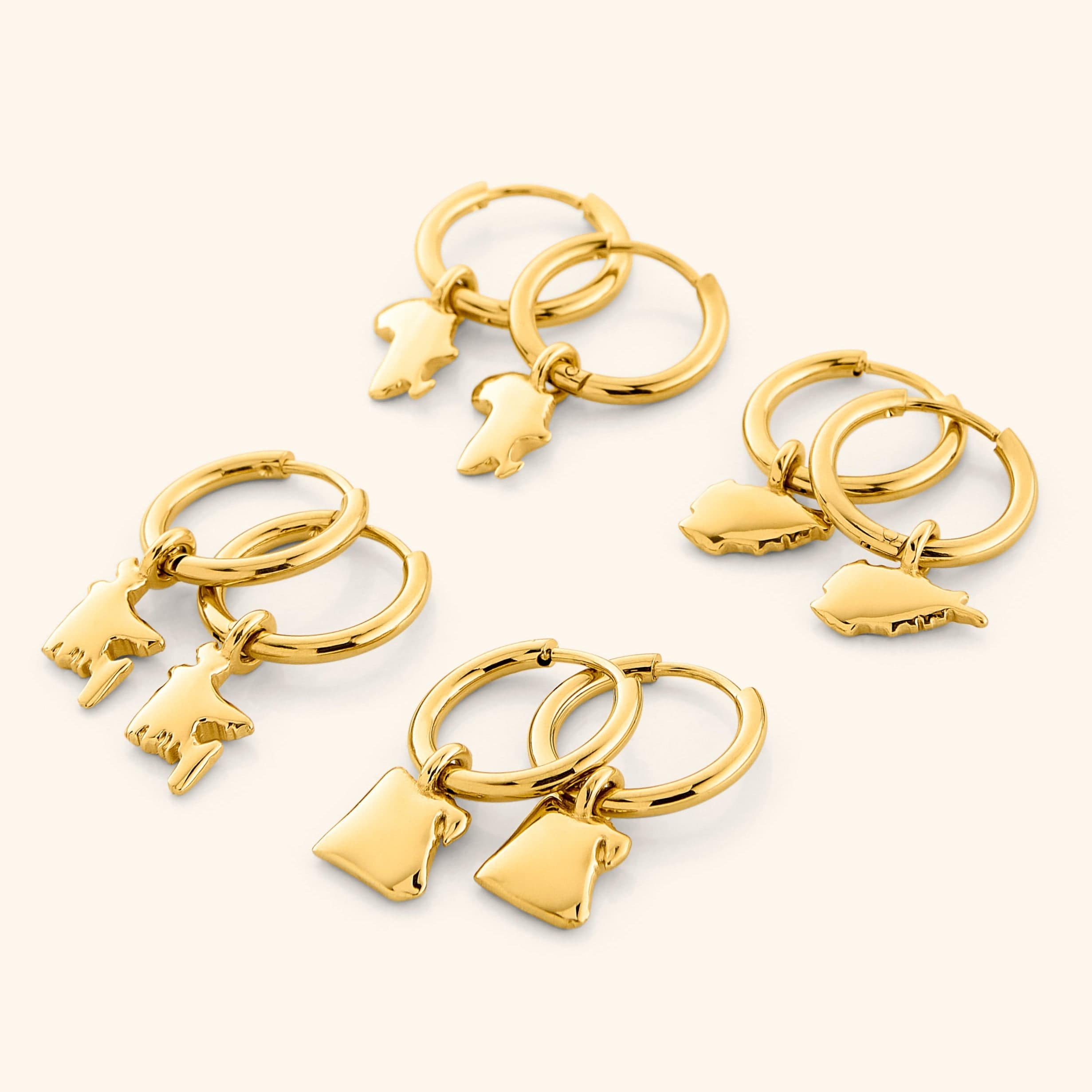 Elegant display of personalized country map gold hoops in a velvet pouch.