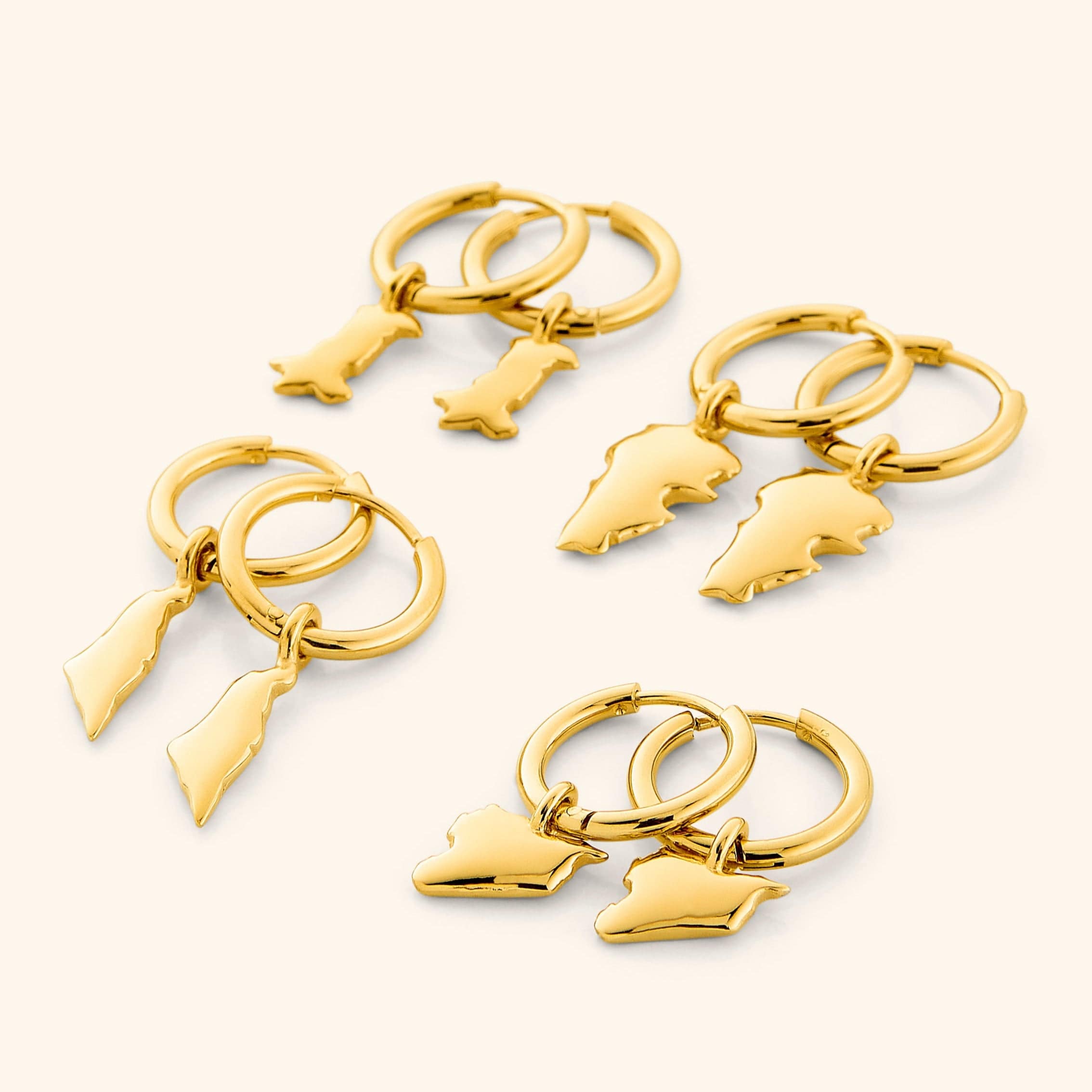 Close-up of personalized country map gold hoops showcasing their intricate design.