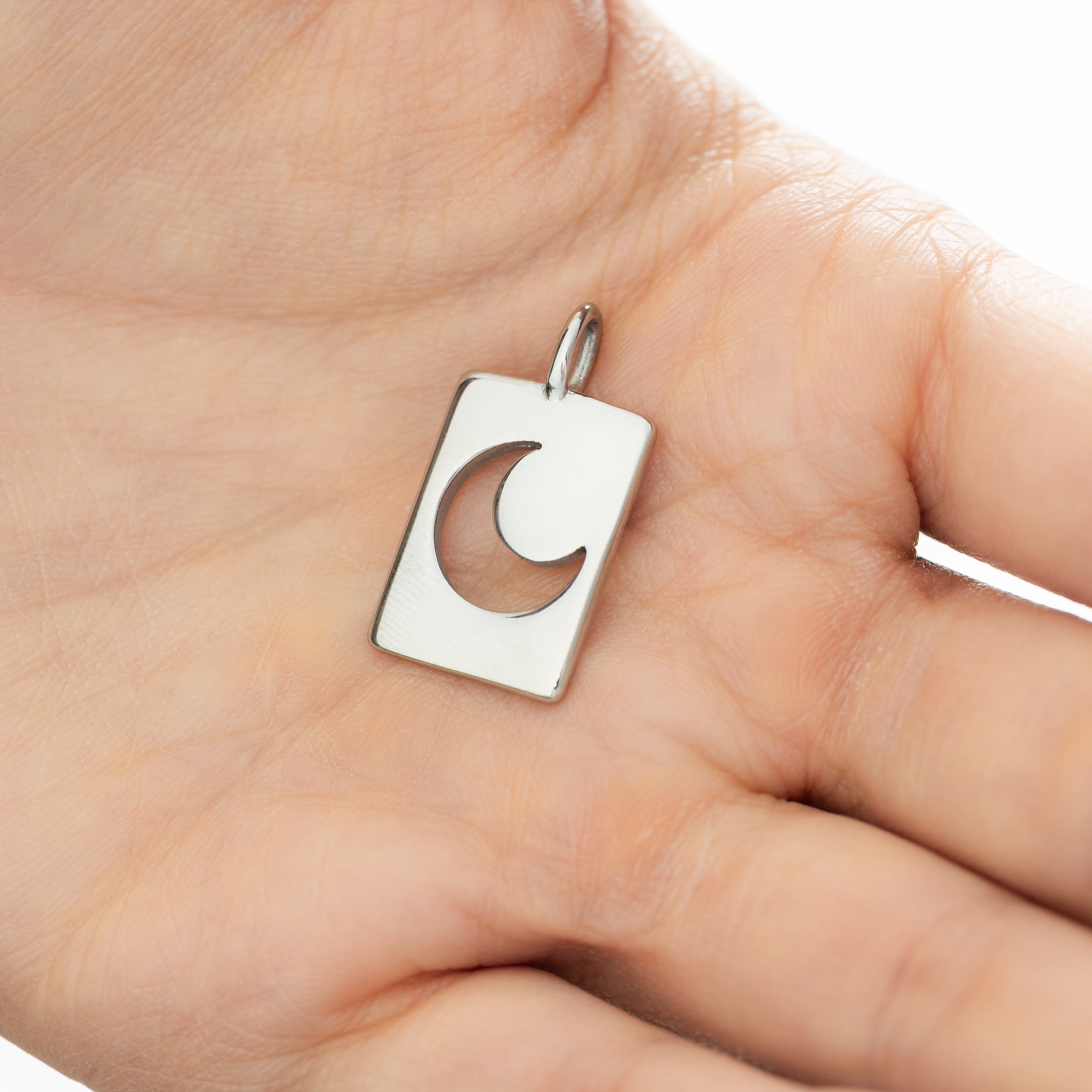 Close-up view of the Celestial Crescent Moon Charm showcasing its gold finish and design.