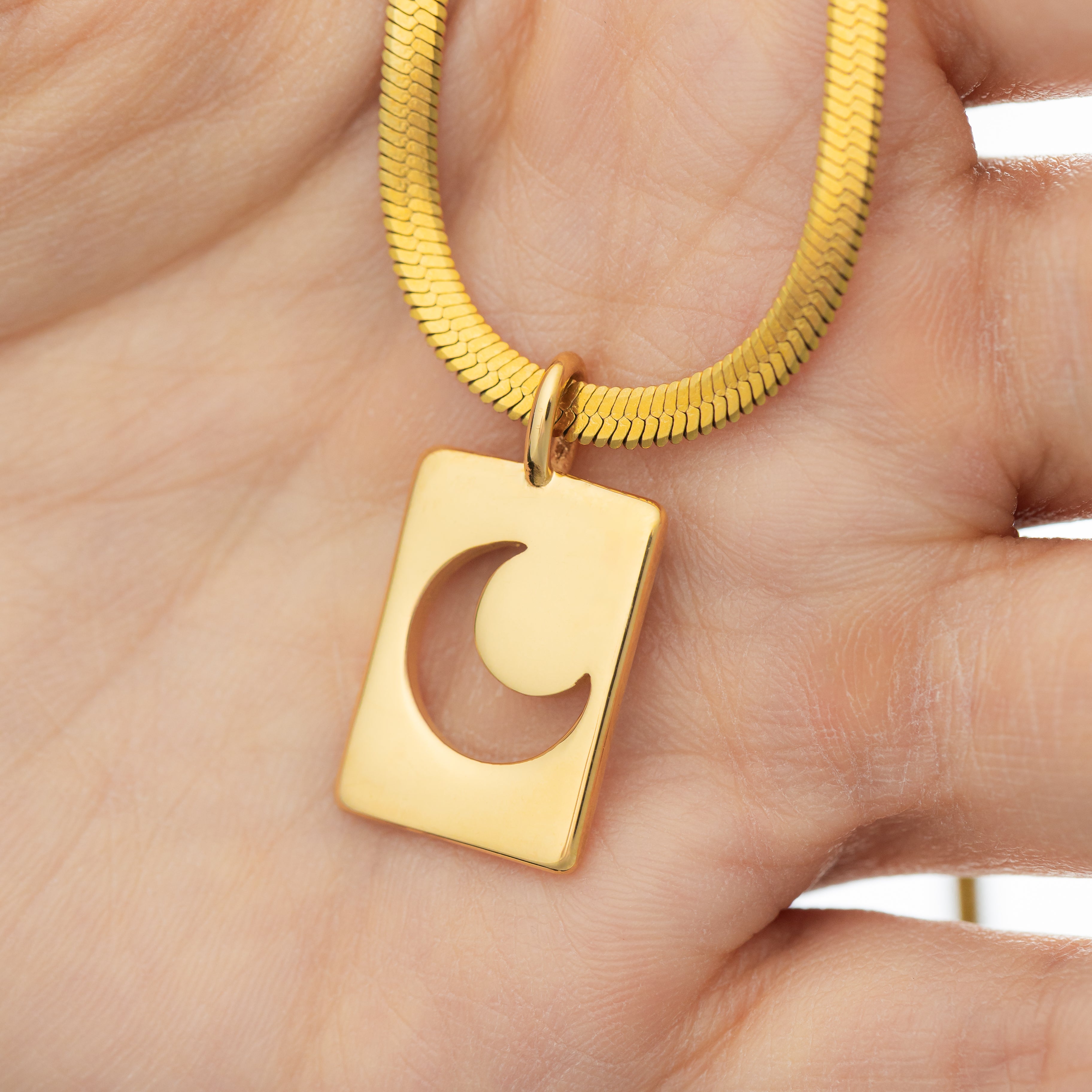 Close-up view of the Celestial Crescent Moon Charm showcasing its gold finish and design.