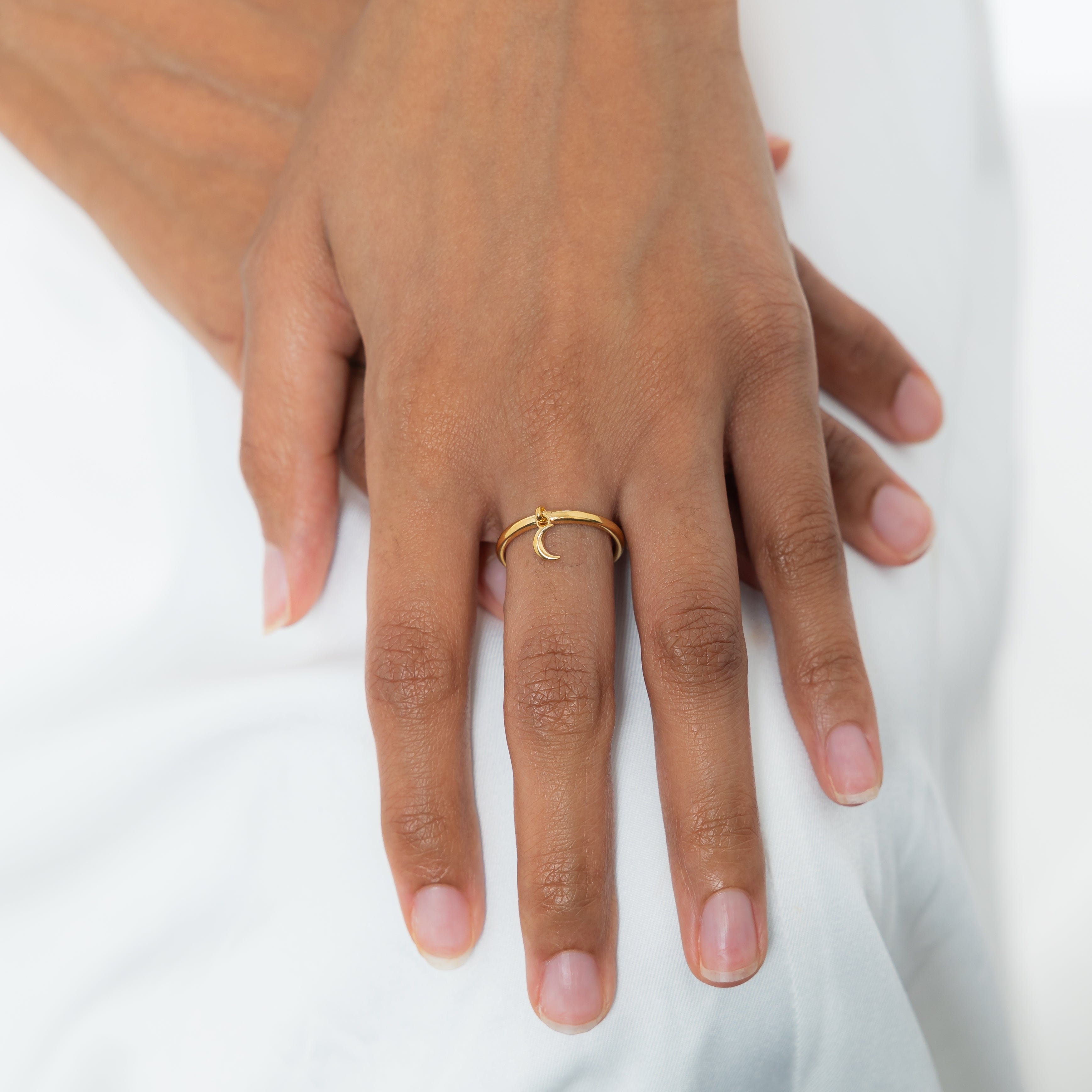 Close-up of crescent ring resting on velvet pouch, highlighting minimalist jewelry details
