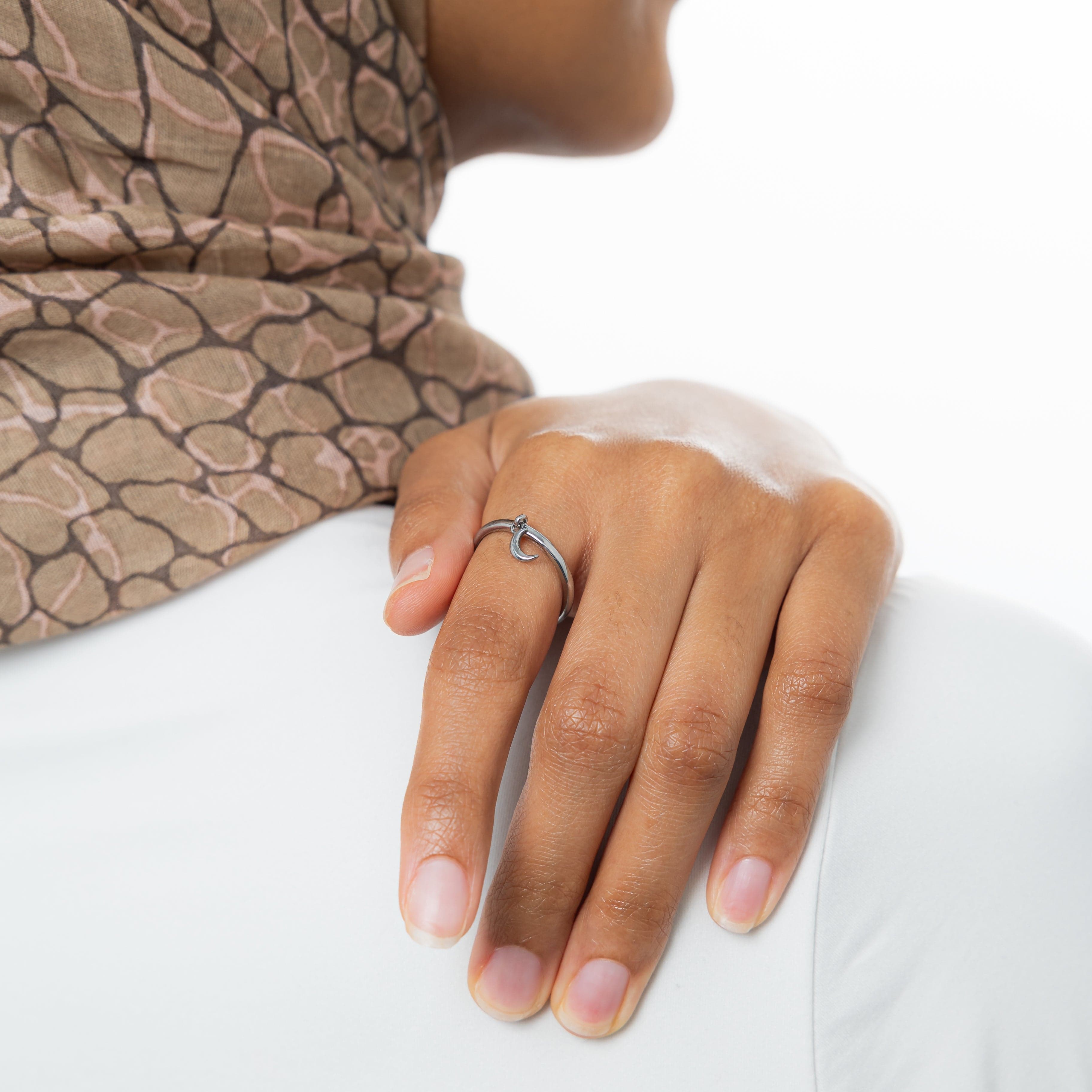 Close-up of crescent ring resting on velvet pouch, highlighting minimalist jewelry details