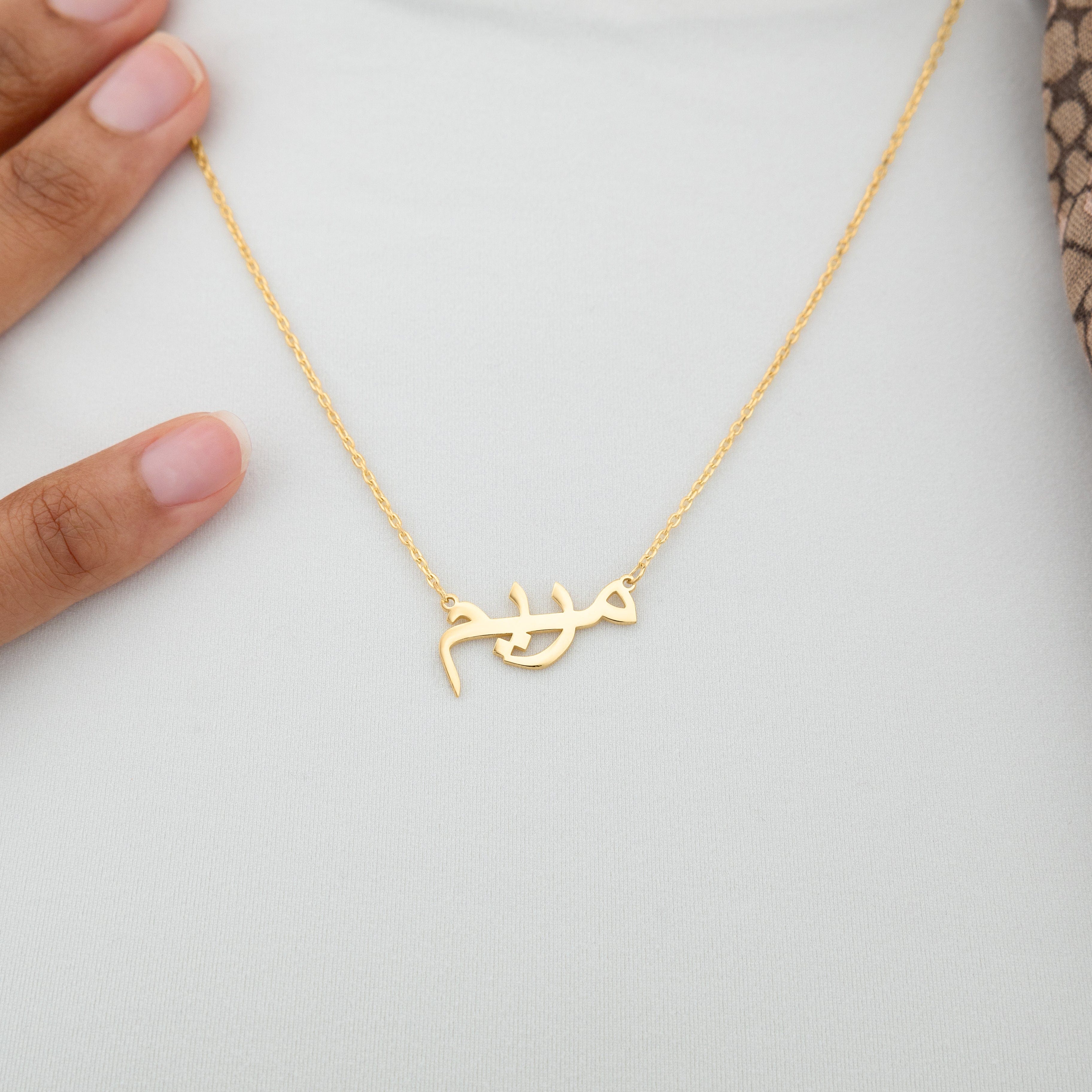 Close-up shot of the unique name necklace in gold, showing intricate details and craftsmanship.