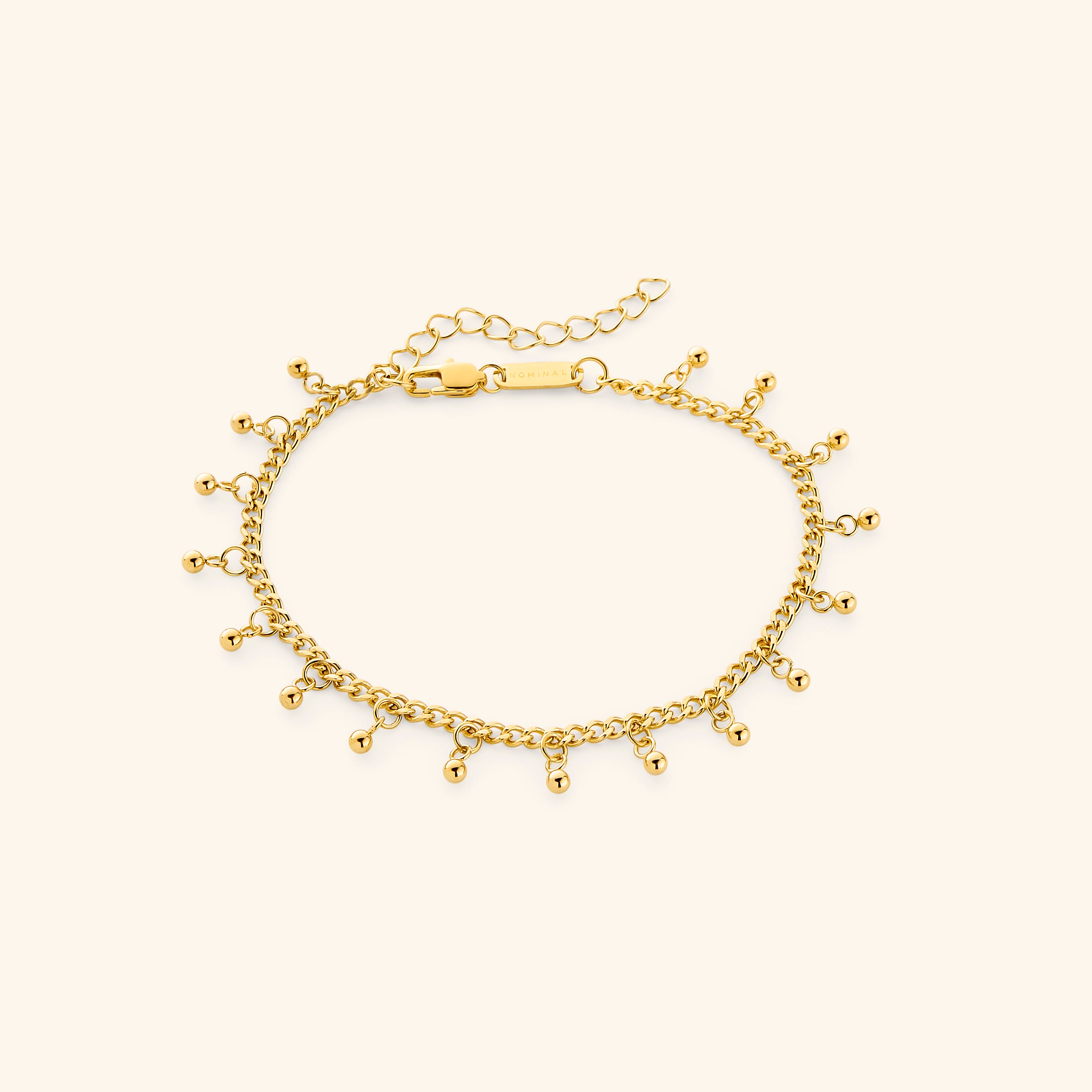 Trendy anklet for summer outfits featuring dangling dotted charms.