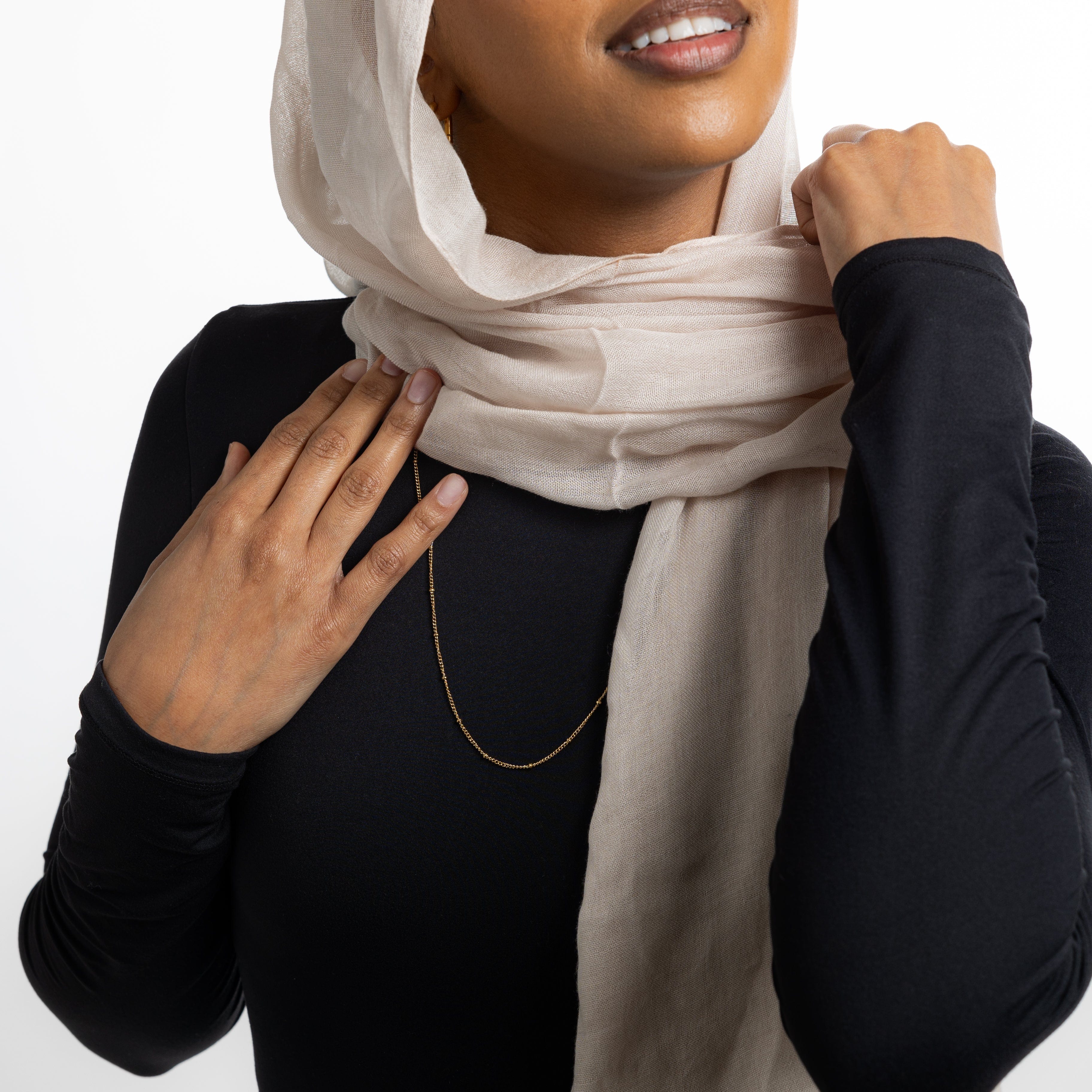 The Dotted Gold Chain Necklace styled with other minimalist jewelry for a layered look.
