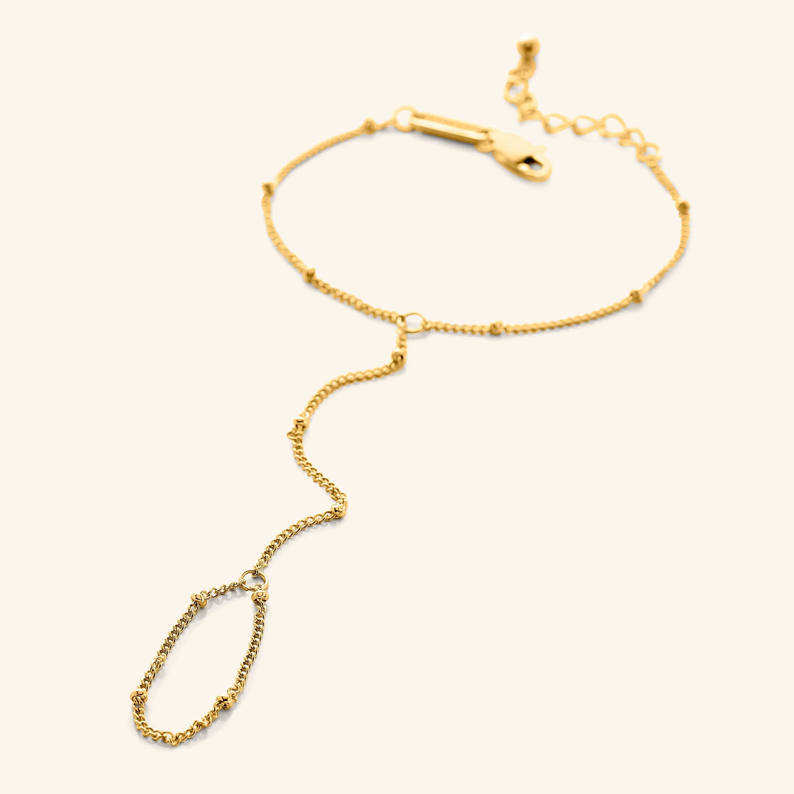 Elegant dotted hand chain displayed on a white background, showcasing its delicate design and gold finish.