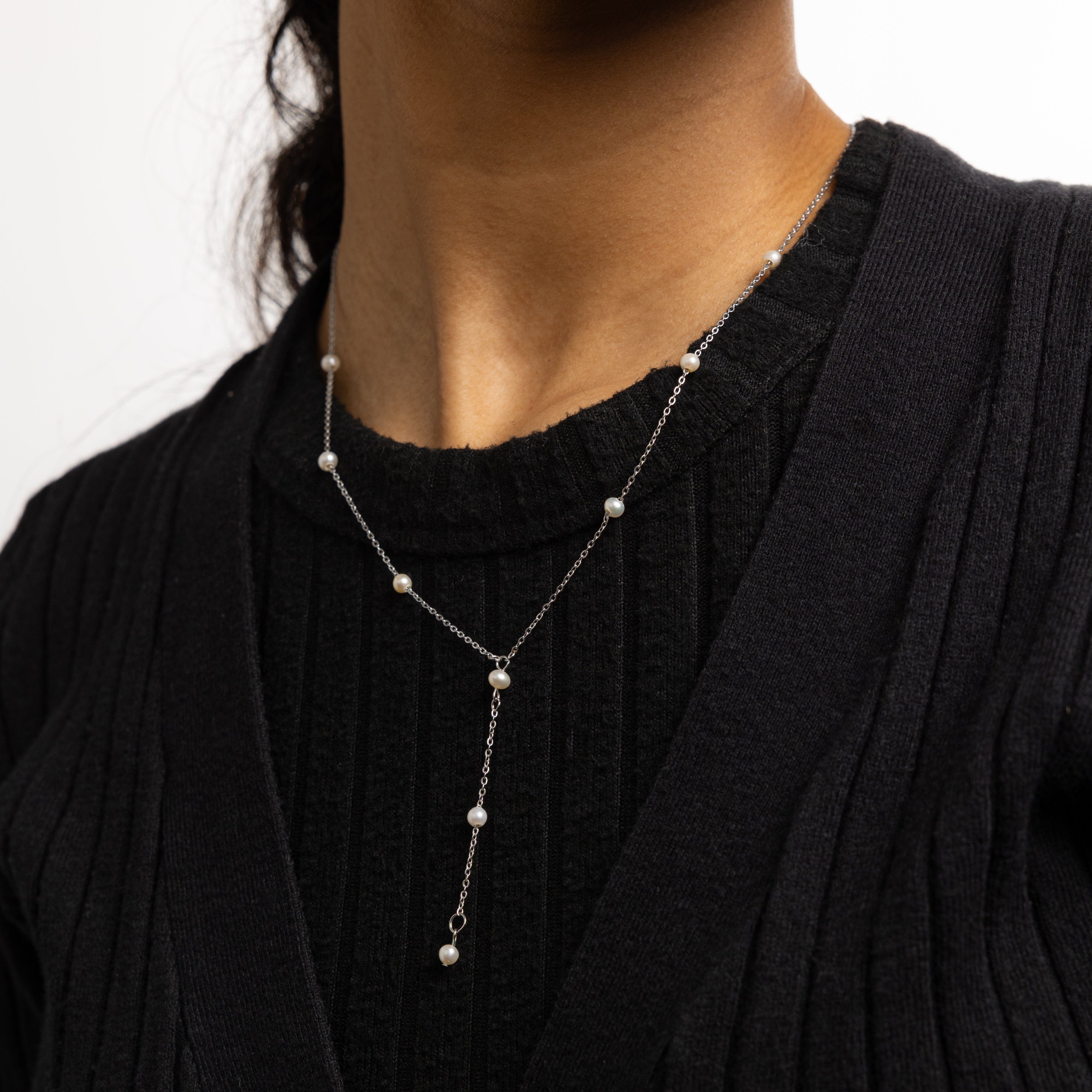 Close-up of pearl necklace highlighting 4mm freshwater pearls and lariat drop