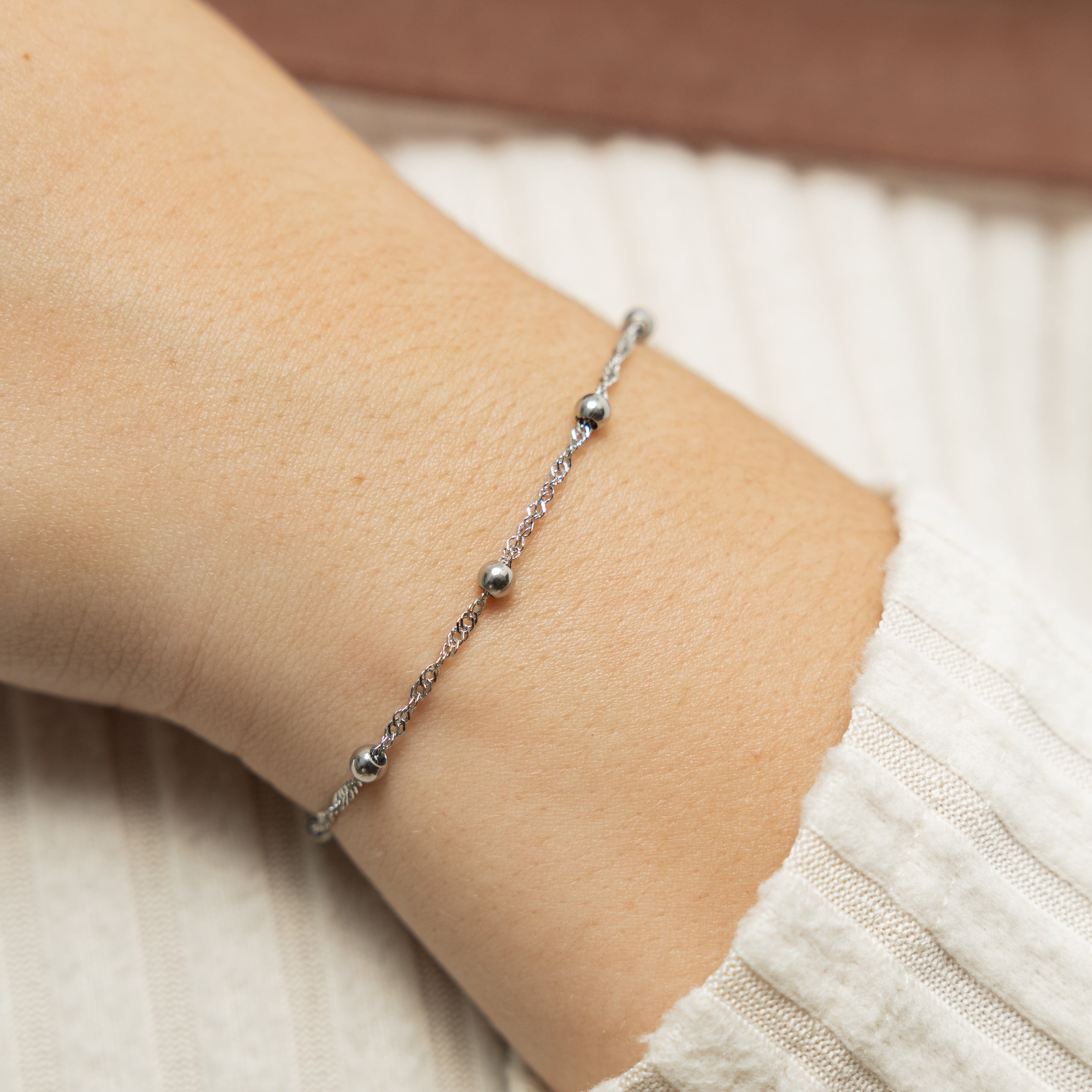 Elegant Dotted Twisted Bracelet displayed in its velvet pouch, emphasizing its luxurious design.