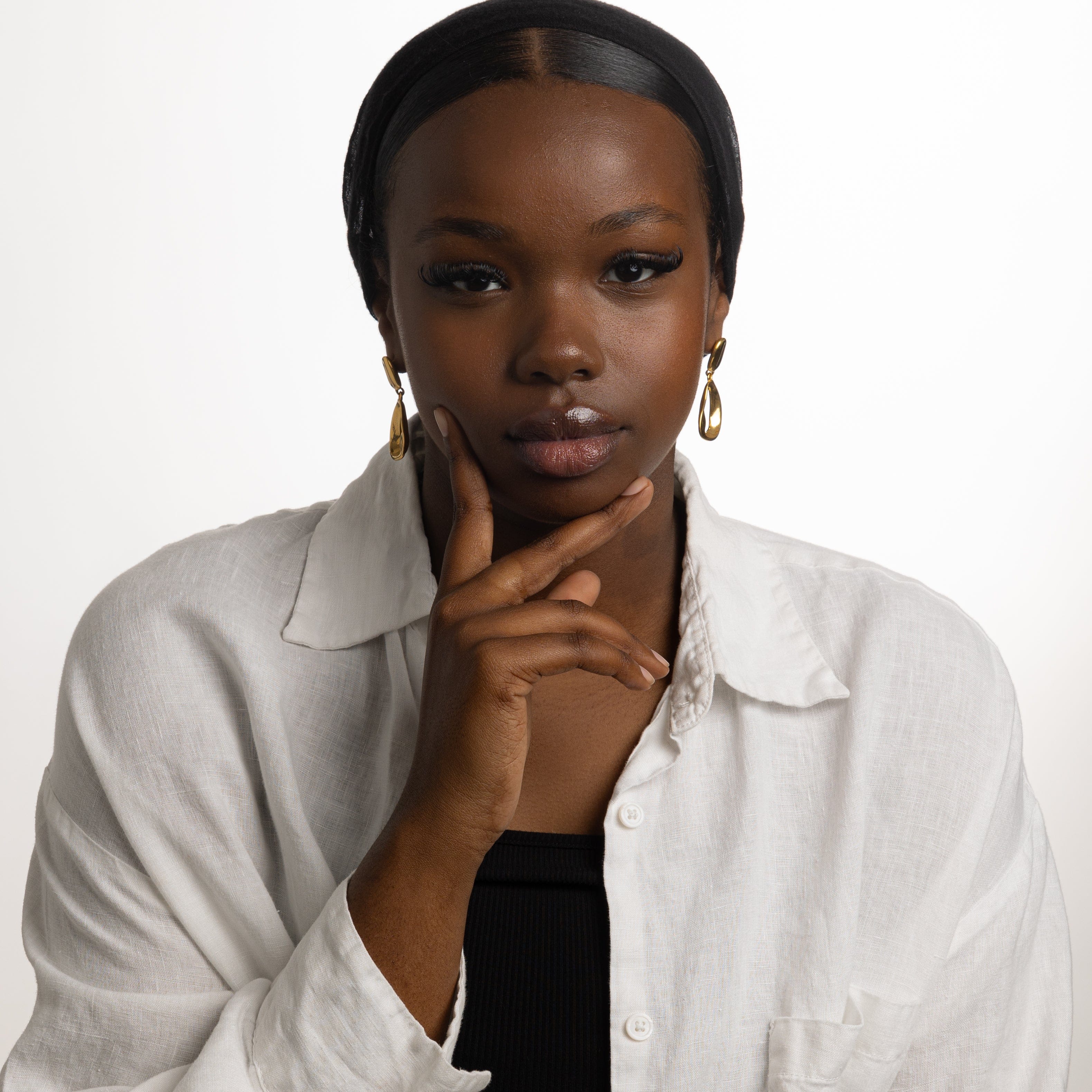 Model wearing Fluid Elegance Gold Statement Earrings at a casual outing, demonstrating their versatility.