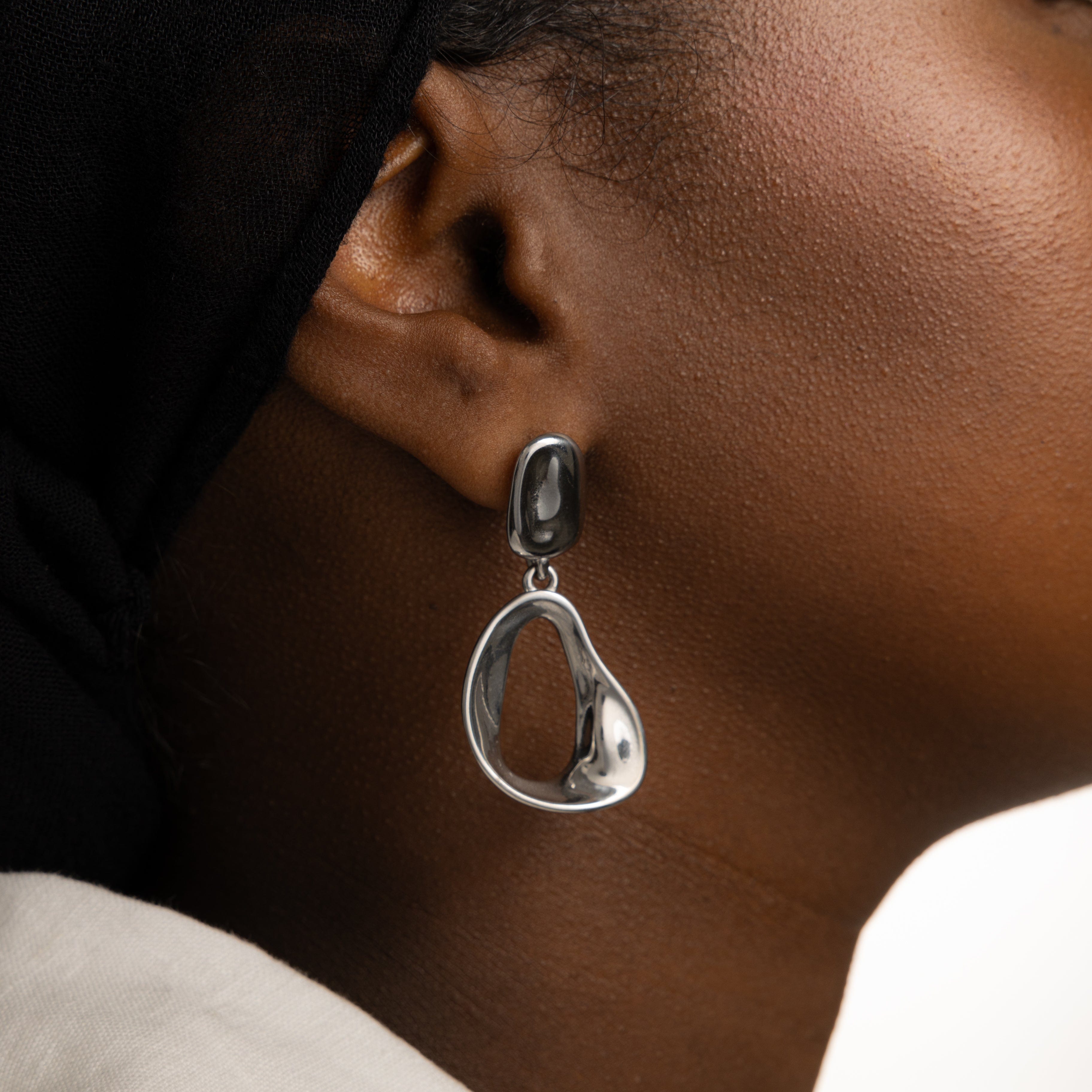 Model wearing Fluid Elegance Gold Statement Earrings at a casual outing, demonstrating their versatility.