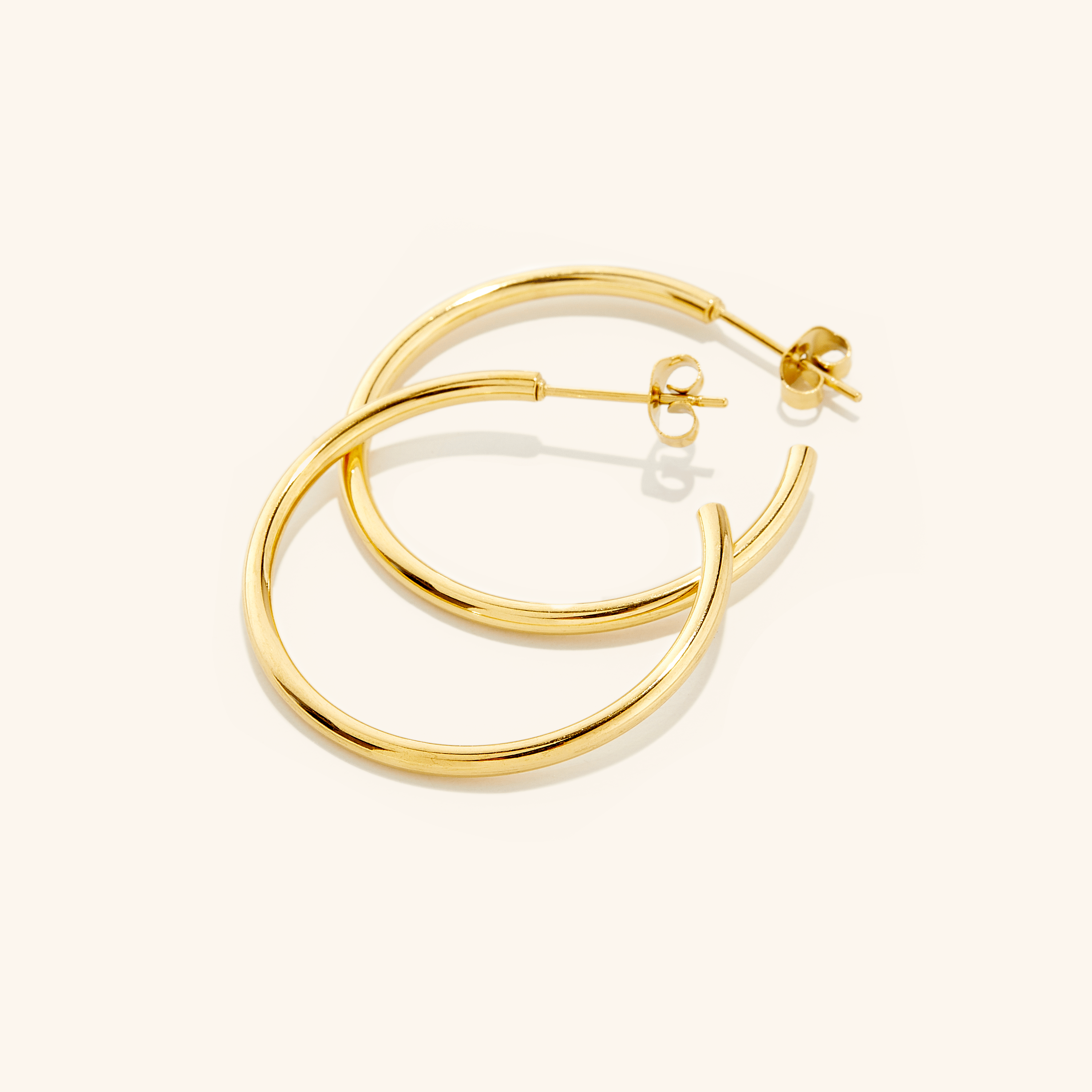 Chic gold hoop earrings in a velvet pouch, showcasing their shine and elegance.